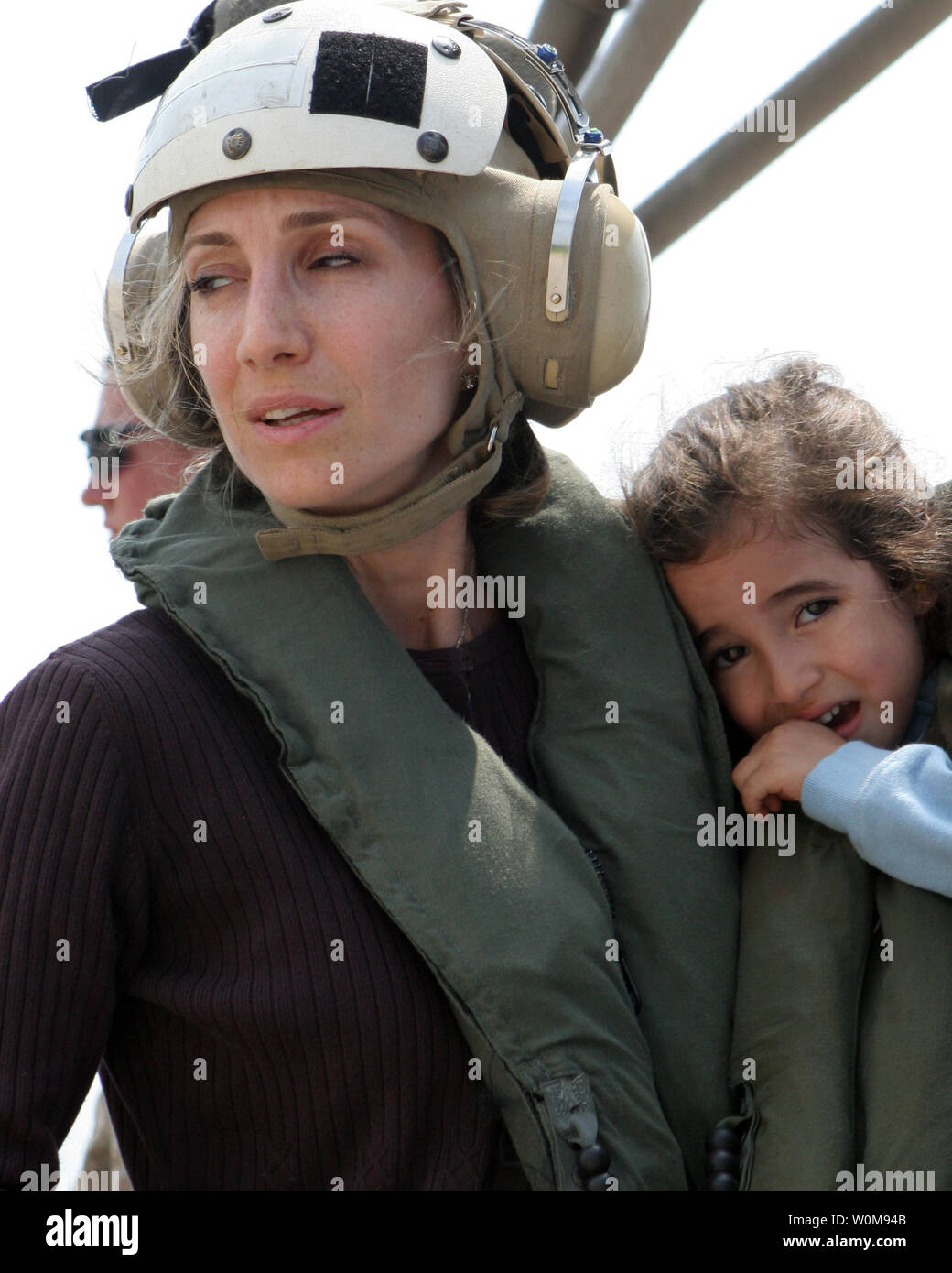 A U.S. citizen holds a child as they wait to board a U.S. Marine Corps CH-53 Super Stallion helicopter at the U.S. Embassy in Beirut, Lebanon, for a flight to Cyprus on July 19, 2006.  At the request of the U.S. Ambassador to Lebanon and at the direction of the Secretary of Defense, the United States Central Command and elements of Task Force 59 are assisting with the departure of U.S. citizens from Lebanon. (UPI Photo/James H. Frank/U.S. Marine Corps) Stock Photo