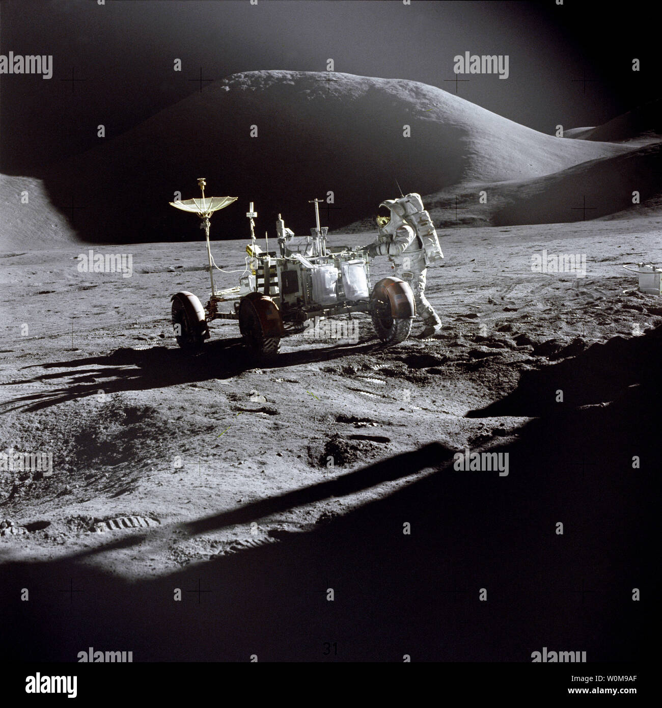 Lunar module pilot James Irwin works at the Lunar Roving Vehicle during the first Apollo 15 lunar surface extravehicular activity at the Hadley-Apennine landing site on July 31, 1971. The shadow of the Lunar Module 'Falcon' is in the foreground. This view is looking northeast, with Mount Hadley in the background. Apollo 15 launched 35 years ago today on July 26, 1971, at 9:34 a.m. EDT from the Kennedy Space Center. Alfred Worden was the mission's command module pilot. (UPI Photo/David R. Scott/NASA) Stock Photo