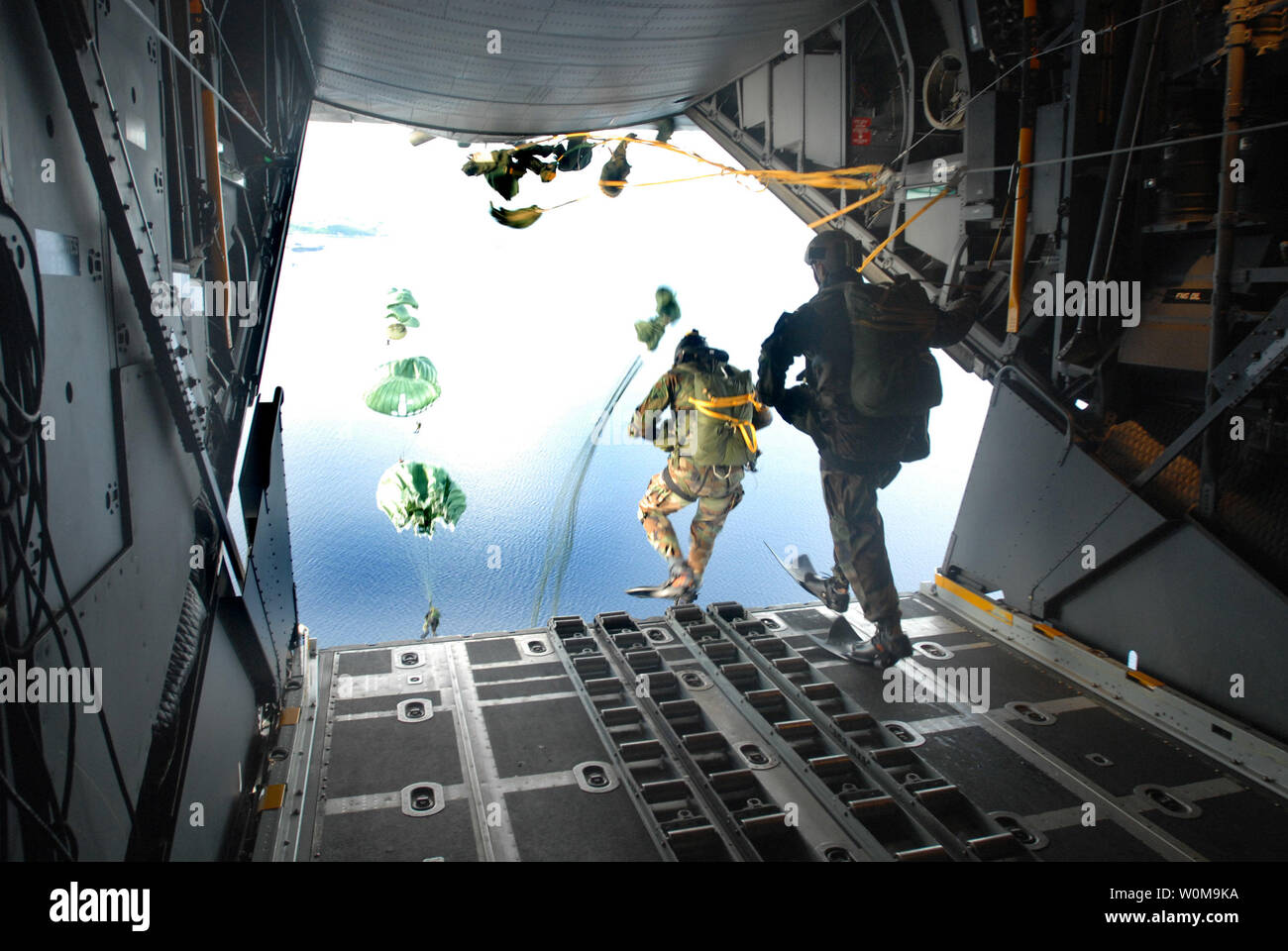 U.S. Air Force pararescuemen from the 31st Rescue Squadron, Kadena, Air Base, Japan, perform a static line jump over water out of a U.S. Air Force C-130 cargo plane on August 29, 2006. The 18th Wing and the 353rd Special Operations Group conducted the mass casualty exercise to test the rescue and emergency care capabilities of Kadena Air Base. (UPI Photo/Jeremy McGuffin/USAF) Stock Photo