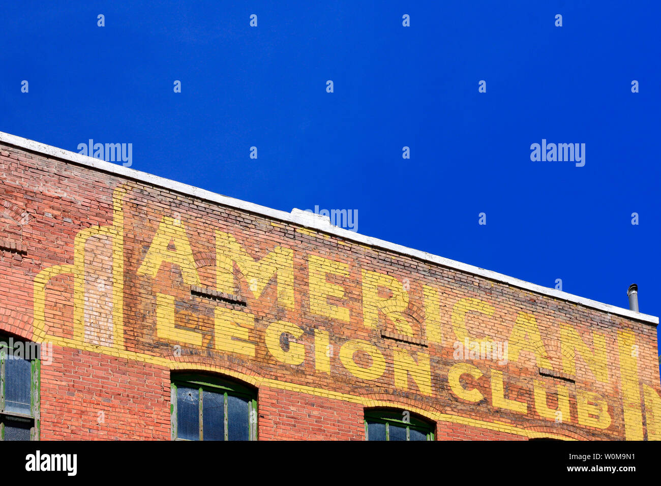 American Legion Club in yellow painted on the side of a brick building