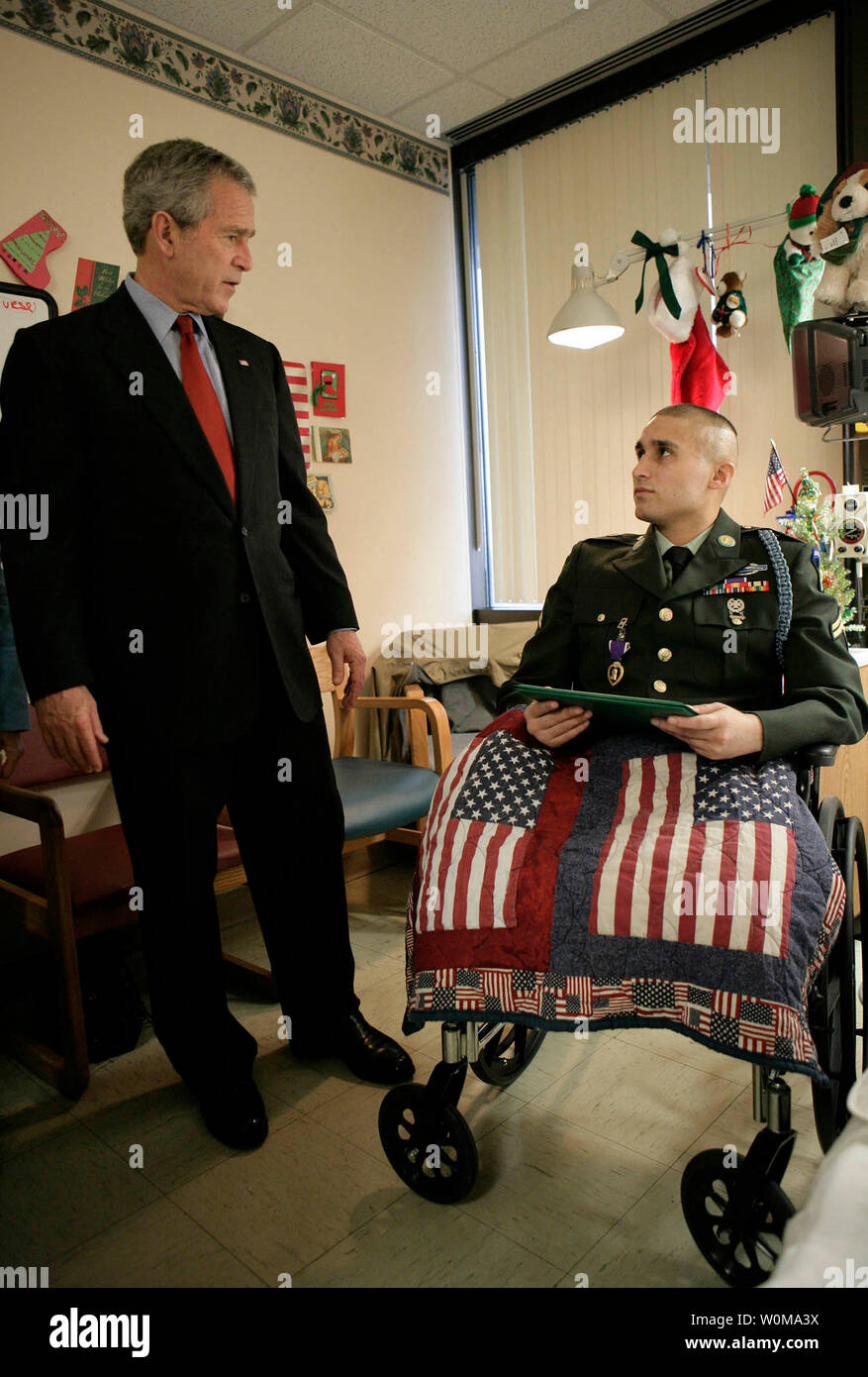 President George W. Bush stands with U.S. Army Cpl. Shane Parsons after presenting him with a Purple Heart  on December 22, 2006, at Walter Reed Army Medical Center in Washington, where the Fostoria, Ohio soldier is recovering from injuries received in Iraq.   (UPI Photo/Eric Draper/White House) Stock Photo