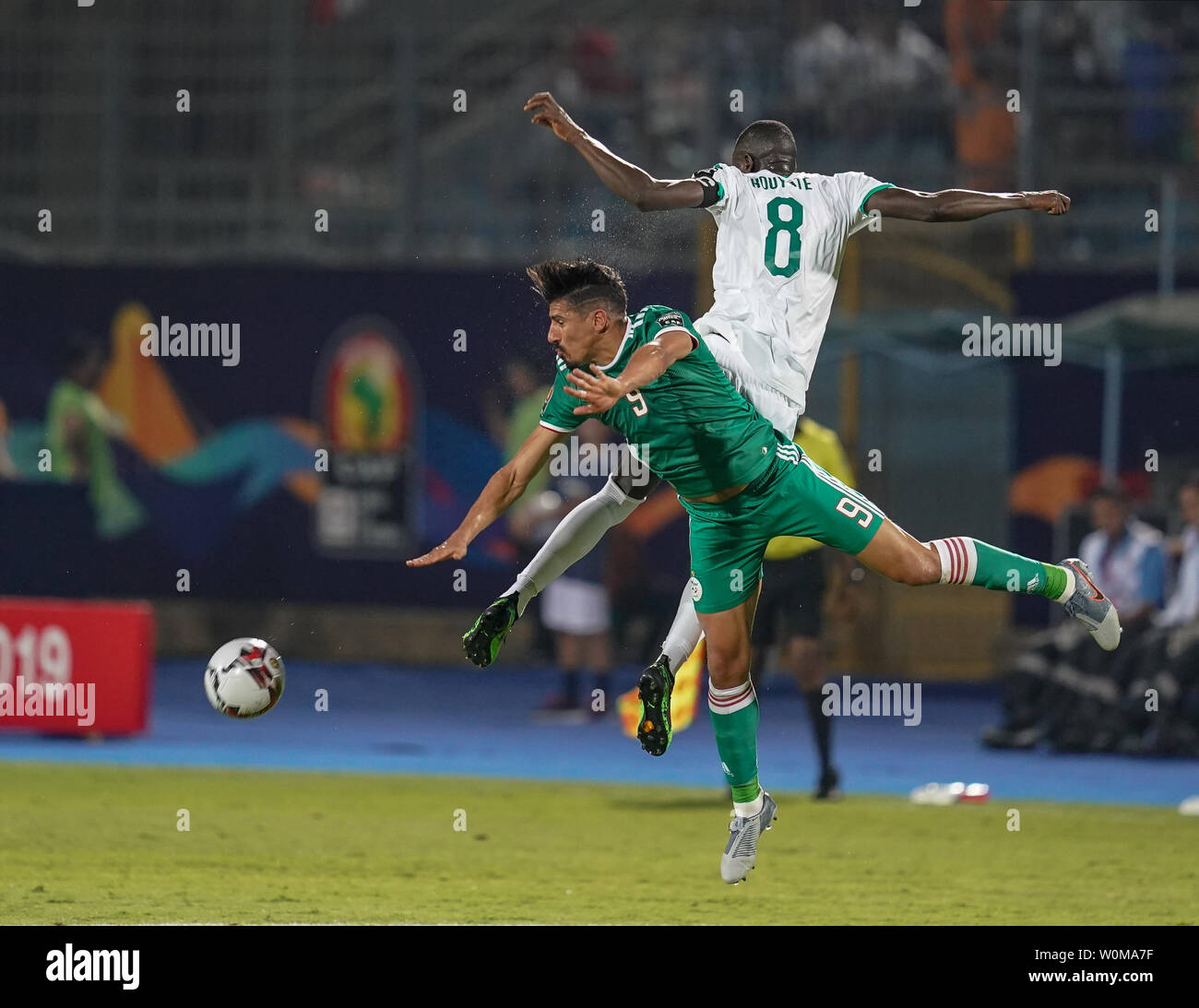 Cairo, Egypt. 27th June, 2019. Cheikhou Kouyate of Senegal and Baghdad Bounedjah of Algeria challenges for the ball during the 2019 African Cup of Nations match between Senegal and Algeria at the 30 June Stadium in Cairo, Egypt. Ulrik Pedersen/CSM/Alamy Live News Stock Photo