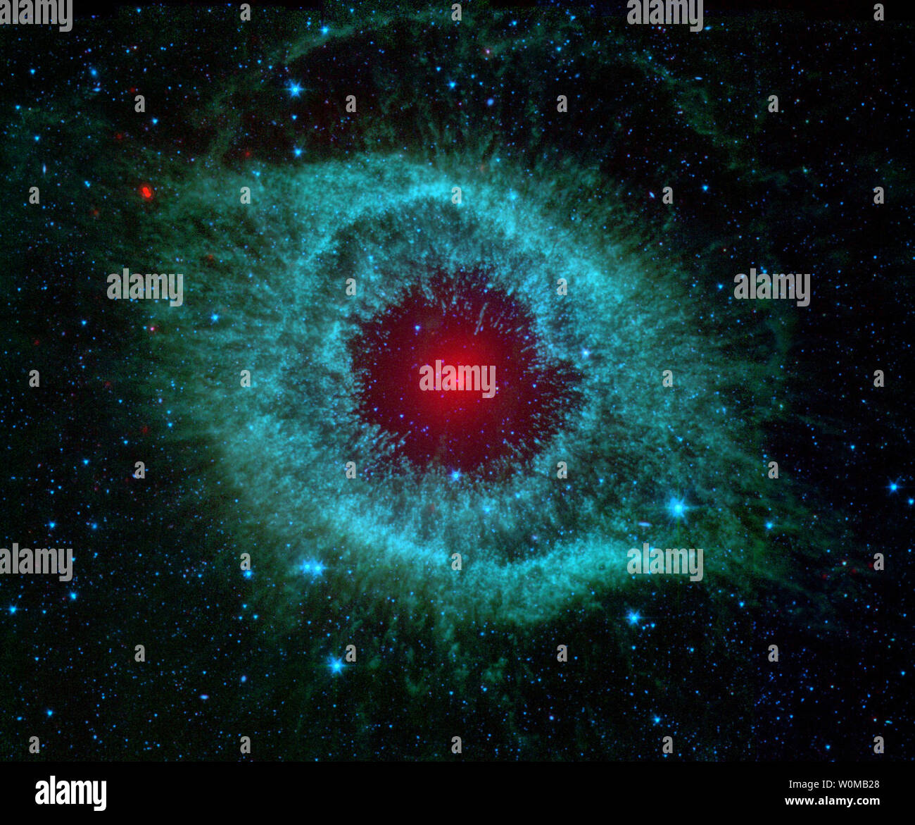 This Spitzer Space Telescope image from NASA shows infrared radiation from the Helix Nebula (NGC 7293), which is 700 light-years away in the constellation Aquarius on July 24, 2007. The two light-year diameter shroud of dust and gas around a central white dwarf has long been considered an excellent example of a planetary nebula, representing the final stages in the evolution of a sun-like star. (UPI Photo/NASA) Stock Photo