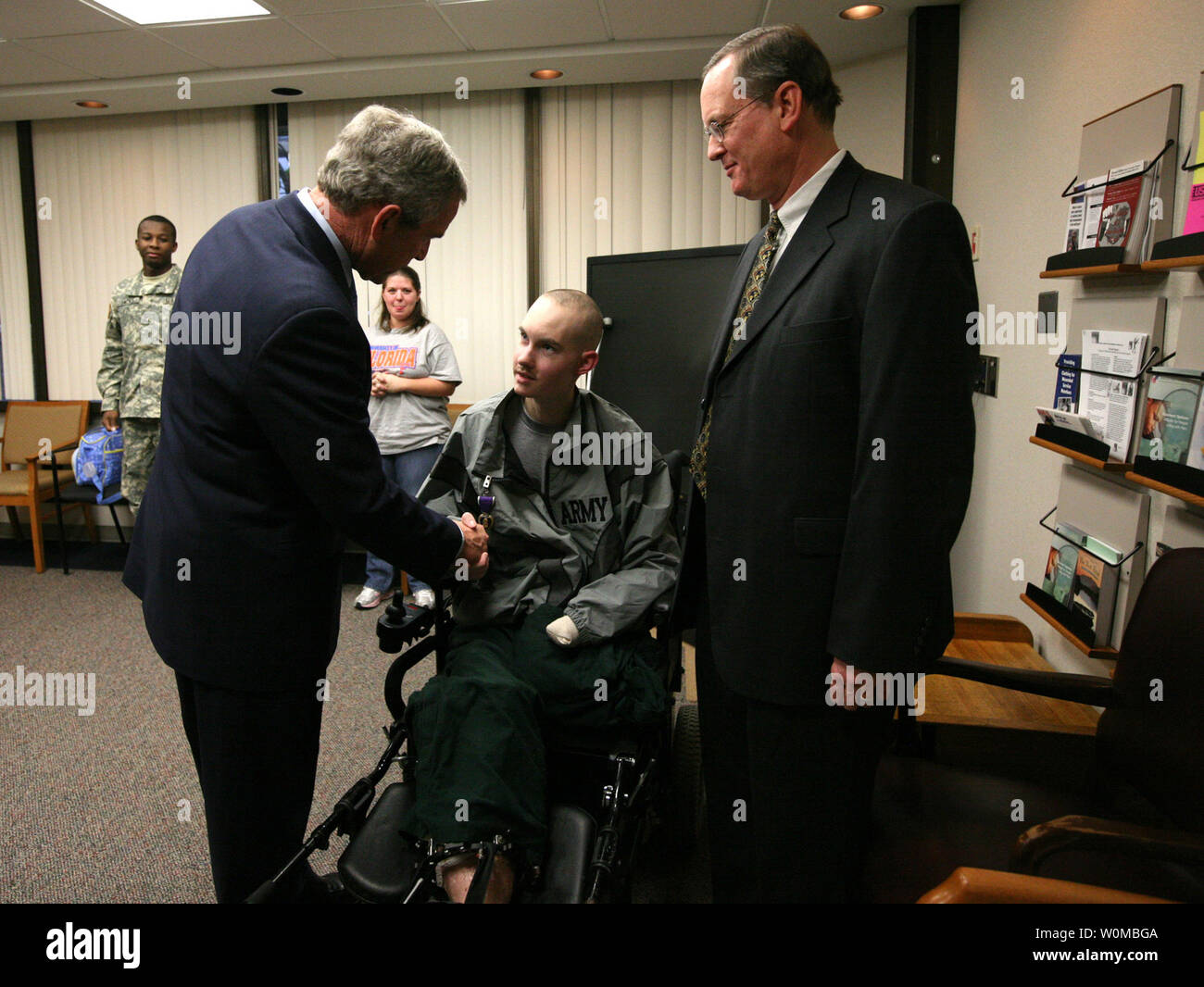 U.S. President George W. Bush (L) presents the Purple Heart to U.S. Army Spc. John C. Hoxie of Philippi, West Virginia during a visit to Walter Reed Army Medical Center in Washington on December 20, 2007. Hoxie is recovering from injuries suffered in Operation Iraqi Freedom. Looking on is the soldier's father, David Hoxie.  (UPI Photo/Joyce. N. Bogosian/White House Press Office). Stock Photo