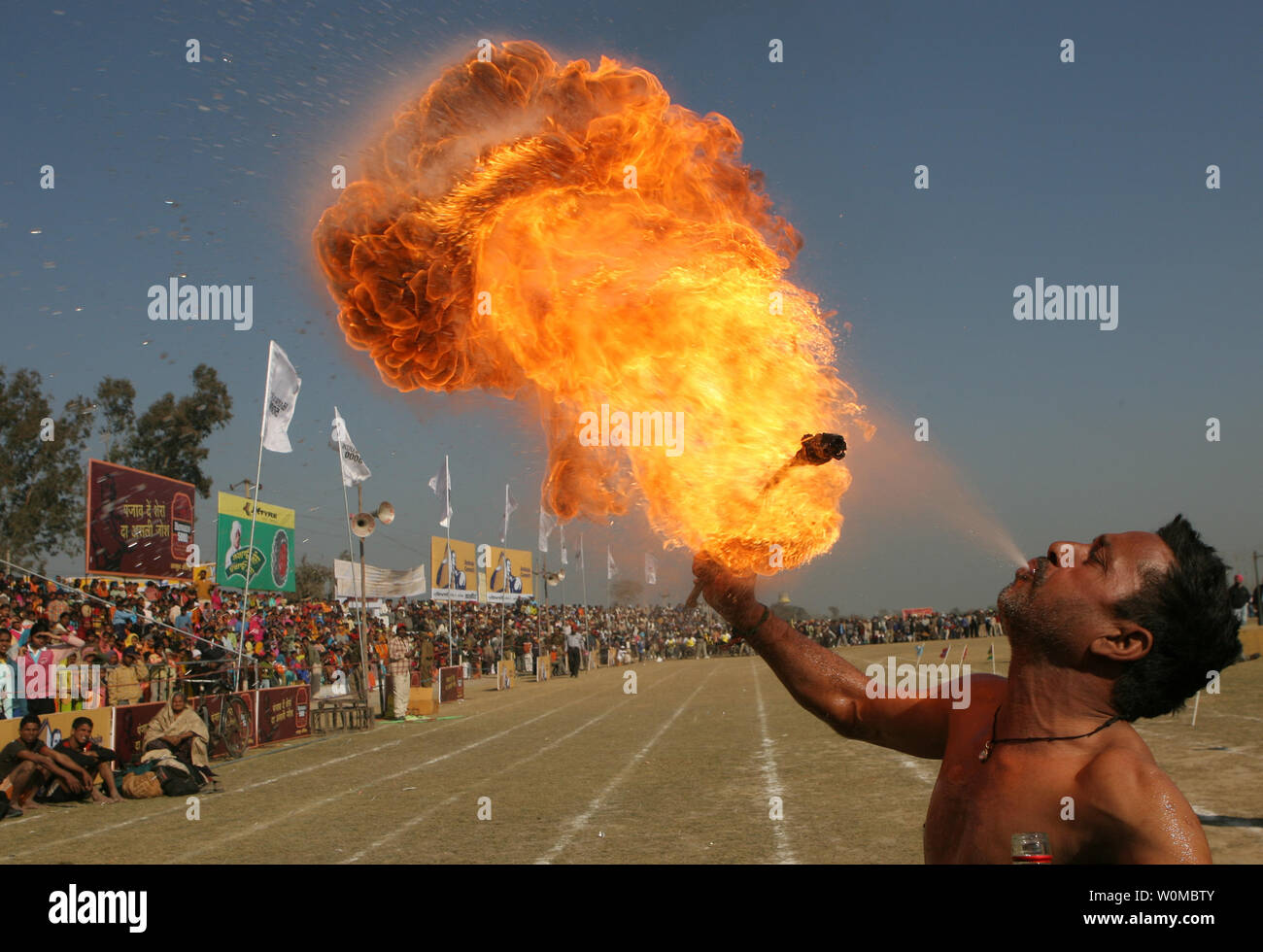 An Indian villager spews fire as he shows his skills during the Kila Raipur Sports Festival, also known as the Rural Olympics near Ludhiana, February 9, 2008. The games started in 1933 and take place over a three-day period during which competitors enter various rural sports events including equestrian events, bullock cart races and shows of strength.  (UPI Photo) Stock Photo