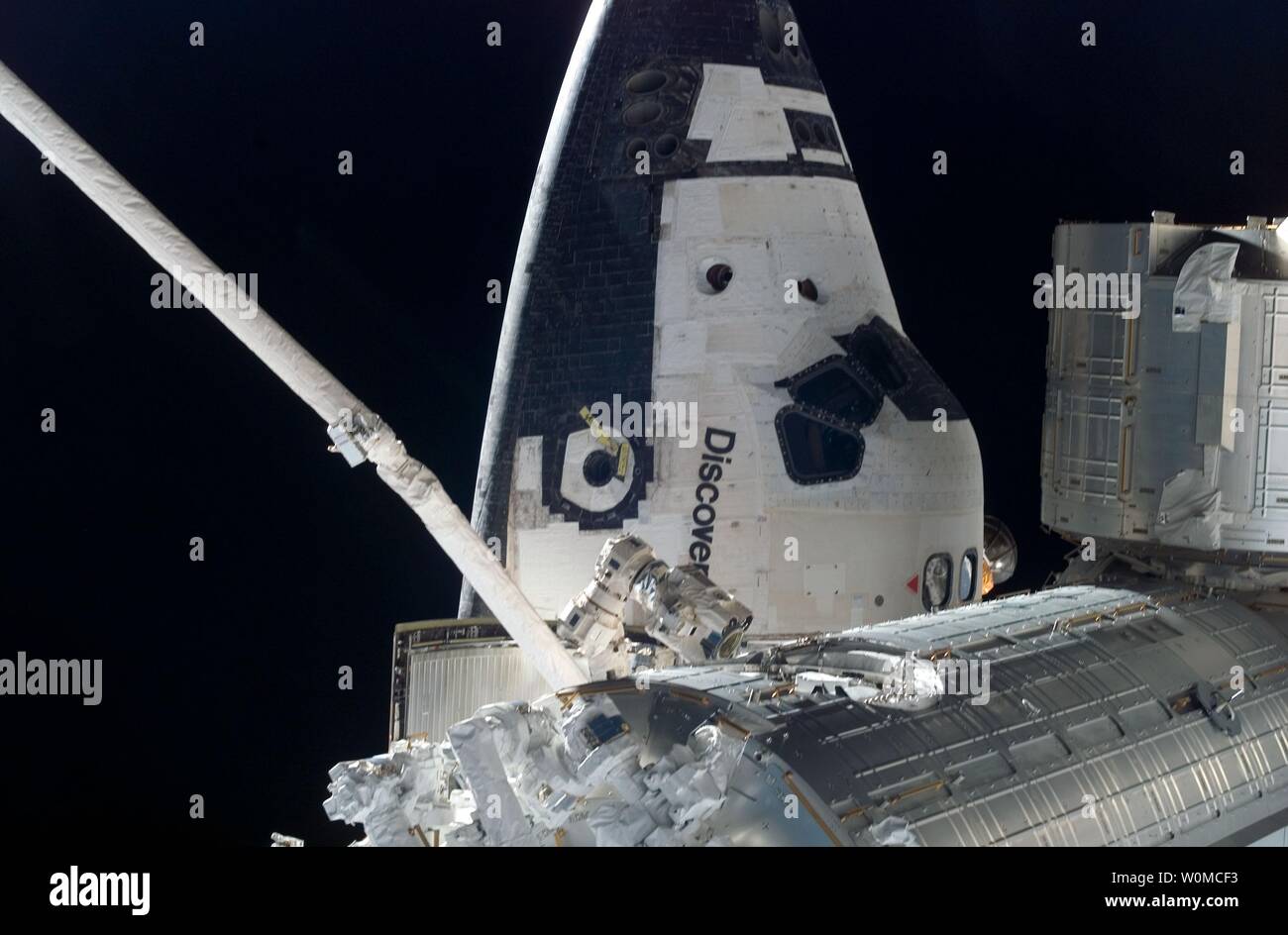 The Forward Section Of The Space Shuttle Discovery While Docked To The International Space Station Partial Views Of The Japanese Pressurized Module Bottom And The Japanese Logistics Module Are Featured In This