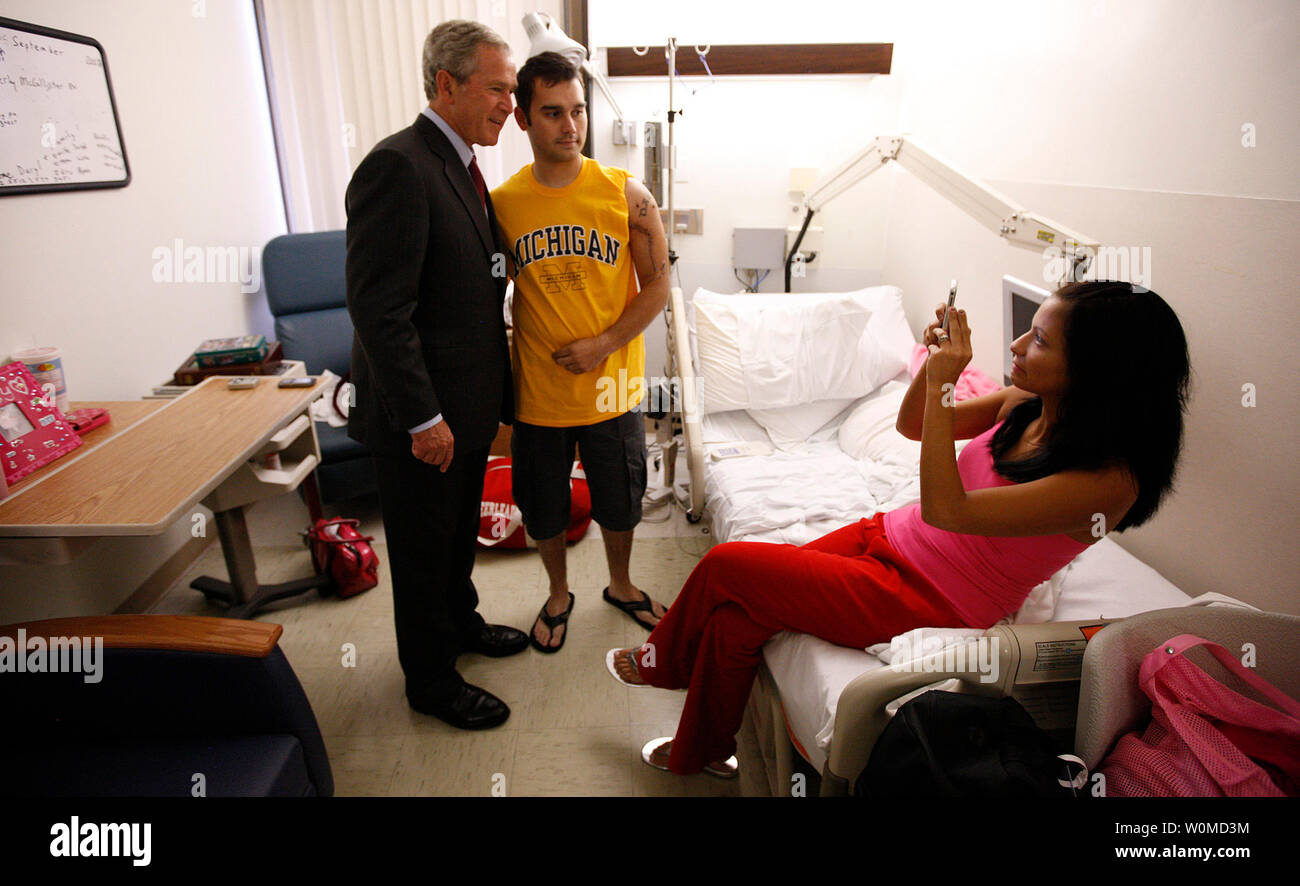 President Bush stands with U.S. Army Spc. Daryl Sullivan of Dyer, Ind., as the soldier's wife, Sarah, takes their photo September 9, 2008, during the President's visit to Walter Reed Army Medical Center in Washington, D.C., where Spc. Sullivan is recovering from wounds received in Iraq.  (UPI Photo/ Eric Draper/White House) Stock Photo