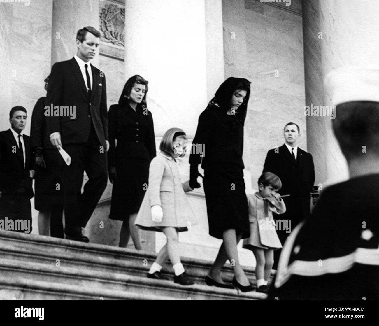 The Kennedy family departs the Capitol on November 25, 1963. (L to R) Peter Lawford, Attorney General Robert Kennedy, Patricia Kennedy Lawford, Caroline Kennedy, First Lady Jacqueline Kennedy, and John F. Kennedy Jr. November 22, 2008 marks the 45th anniversary of the day President Kennedy was assassinated in Dallas, Texas. (UPI Photo/Abbie Rowe/John F. Kennedy Presidential Library & Museum) Stock Photo