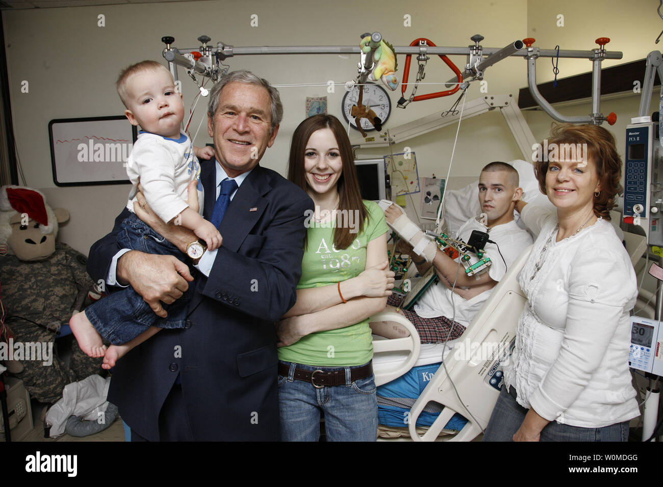 President George W. Bush poses for a picture with the family of U.S. Army Cpl. Isaac Jensen of Layton, Utah on December 22, 2008 in Washington D.C., during a visit to Walter Reed Army Medical Center, where the soldier is recovering from injuries suffered in the war in Iraq.  (L-R)  son James (15 months), Bush, wife Bethany,  U.S. Army Cpl. Isaac Jensen,  and mother, Eva Francis.    (UPI Photo/Eric Draper/White House) Stock Photo