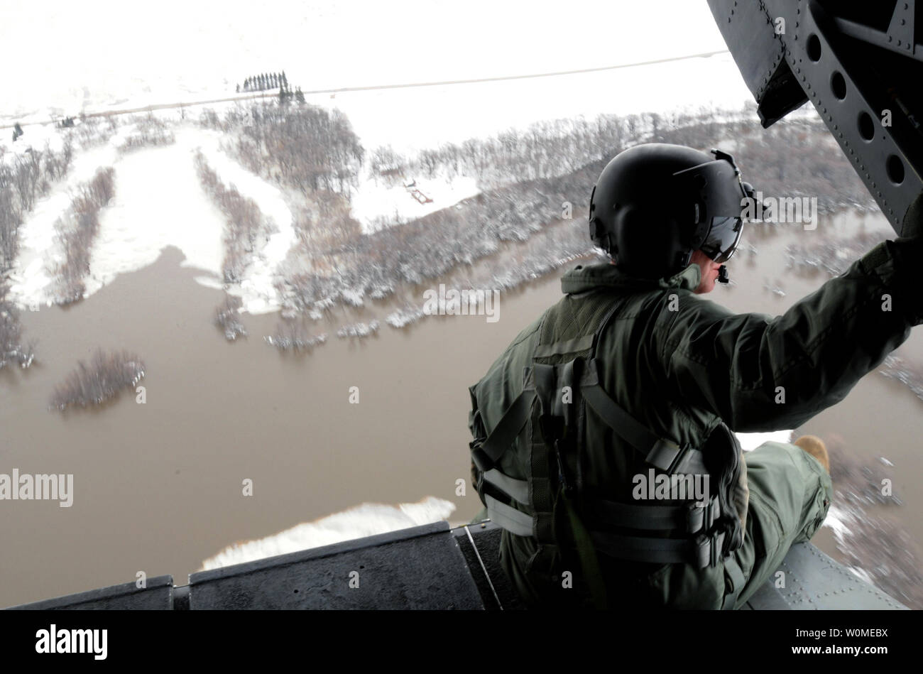 U.S. Army Staff Sgt. Jon Scarber, a flight engineer, looks out over the flooded Red River along the North Dakota/Minnesota border from a CH-47D Chinook helicopter on April 1, 2009. The Montana Army National Guard is assisting flood relief efforts and is conducting orientation flights to familiarize aviators and Soldiers with possible hazards in the region. (UPI Photo/Roger M. Dey/U.S. Army) Stock Photo