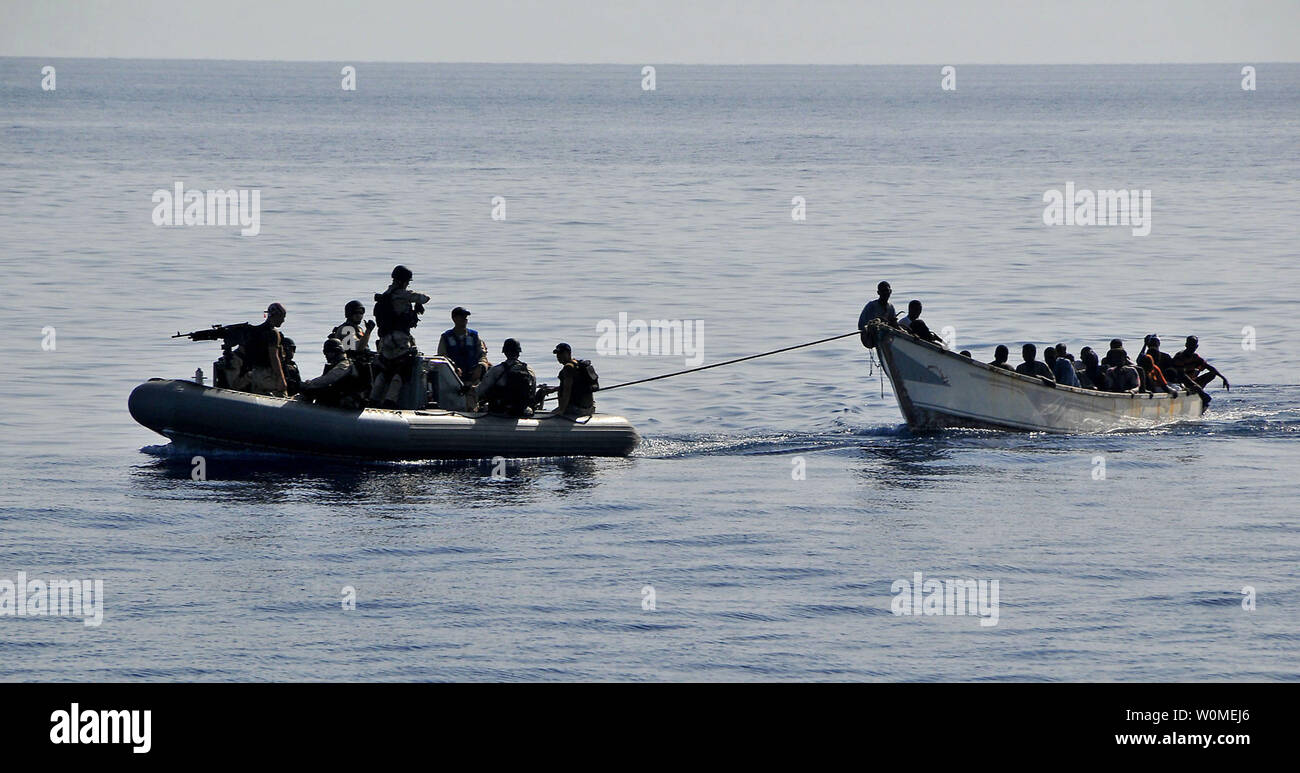 Members of the visit, board, search, and seizure team from the guided-missile cruiser USS Lake Champlain (CG 57) tow a disabled skiff carrying 52 Somali migrants in the Gulf of Aden on May 24, 2009. The skiff was spotted in distress by Lake Champlain helicopter pilots while patrolling the area.    (UPI Photo/Daniel Barker/U.S. Navy) Stock Photo