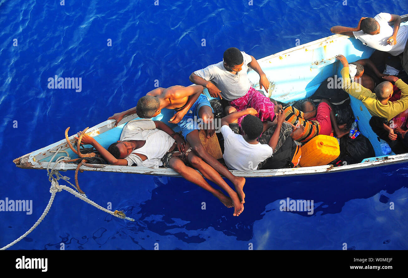 Somali migrants in a disabled skiff wait for assistance from Sailors aboard the guided-missile cruiser USS Lake Champlain (CG 57) in the Gulf of Aden on May 24, 2009. The skiff, originally ferrying 52 passengers, was spotted in distress by helicopter pilots assigned to the 'Wolfpack' of Helicopter Anti-Submarine Squadron Light (HSL) 45 while patrolling the area.  (UPI Photo/Daniel Barker/U.S. Navy) Stock Photo