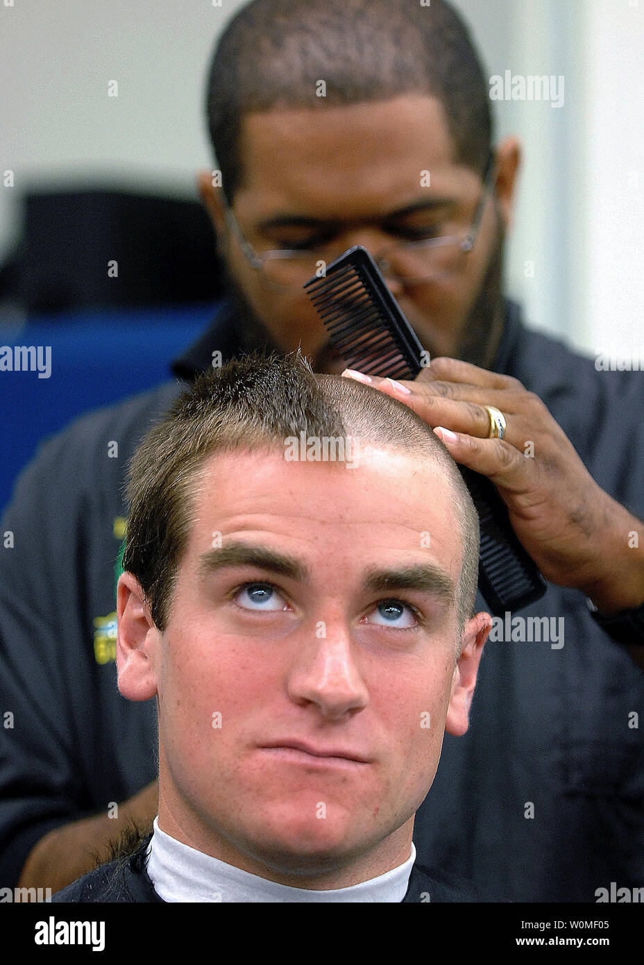 A plebe receives his first Navy haircut during Induction Day at the U.S. Naval Academy in Annapolis, Maryland on July 1, 2009. Induction Day is the beginning of Plebe Summer, a demanding seven-week orientation that marks the period that roughly 1,200 selected candidates are transformed from civilians to Midshipmen. (UPI Photo/Gin Kai/U.S. Navy) Stock Photo