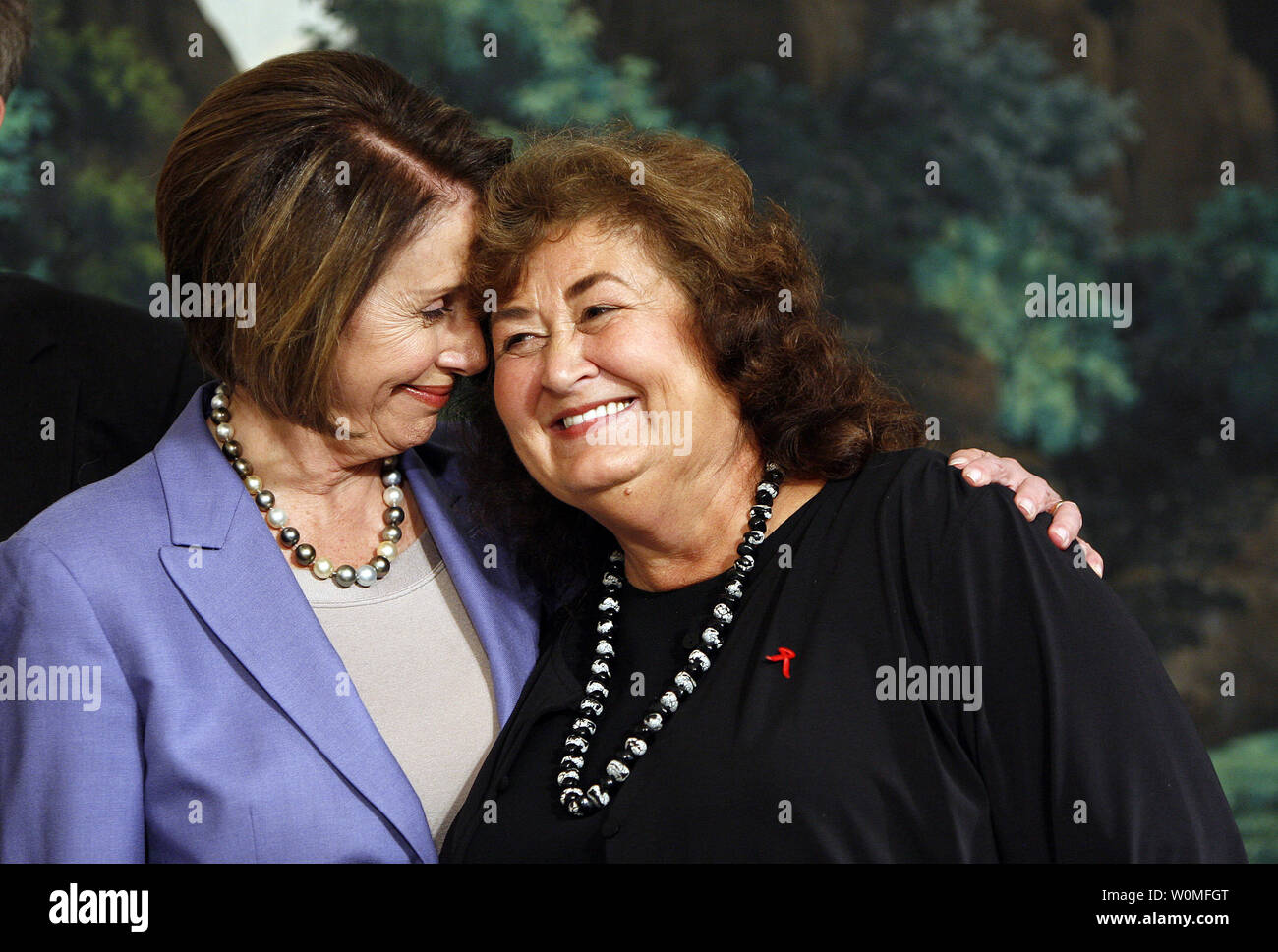 Speaker of the House, Nancy Pelosi (D-CA) (L) embrace's Jeanne White-Ginder, mother of Ryan White, before U.S. President Barack Obama signed the Ryan White HIV/AIDS treatment extension act of 2009 in the Diplomatic Room of the White House in Washington on October 30, 2009. The act is the largest federally funded program for people living with HIV/AIDS in the U.S. It was named in honor of Ryan White, a  teenager who contracted AIDS through a tainted hemophilia treatment in 1984 and became a well-known advocate for AIDS research and awareness, until his death on April 8, 1990. Stock Photo