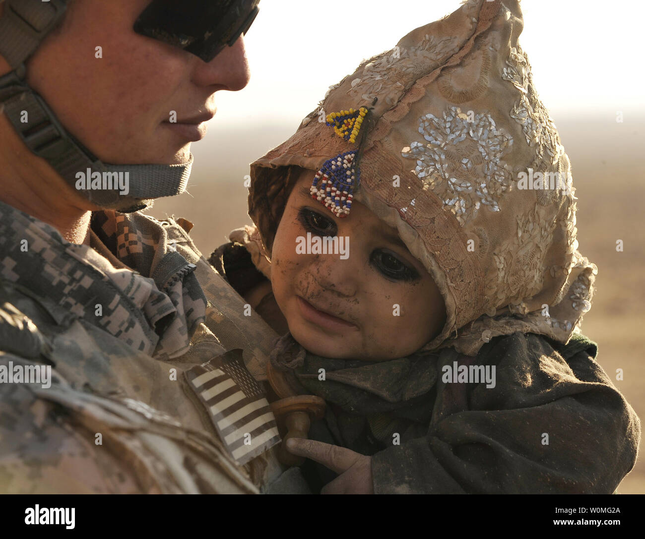 A U.S. Soldier comforts an Afghan child during a medical outreach in a Kuchi camp near Hutal, Kandahar province, Afghanistan on January 5, 2010. UPI/Dayton Mitchell/U.S. Air Force Stock Photo