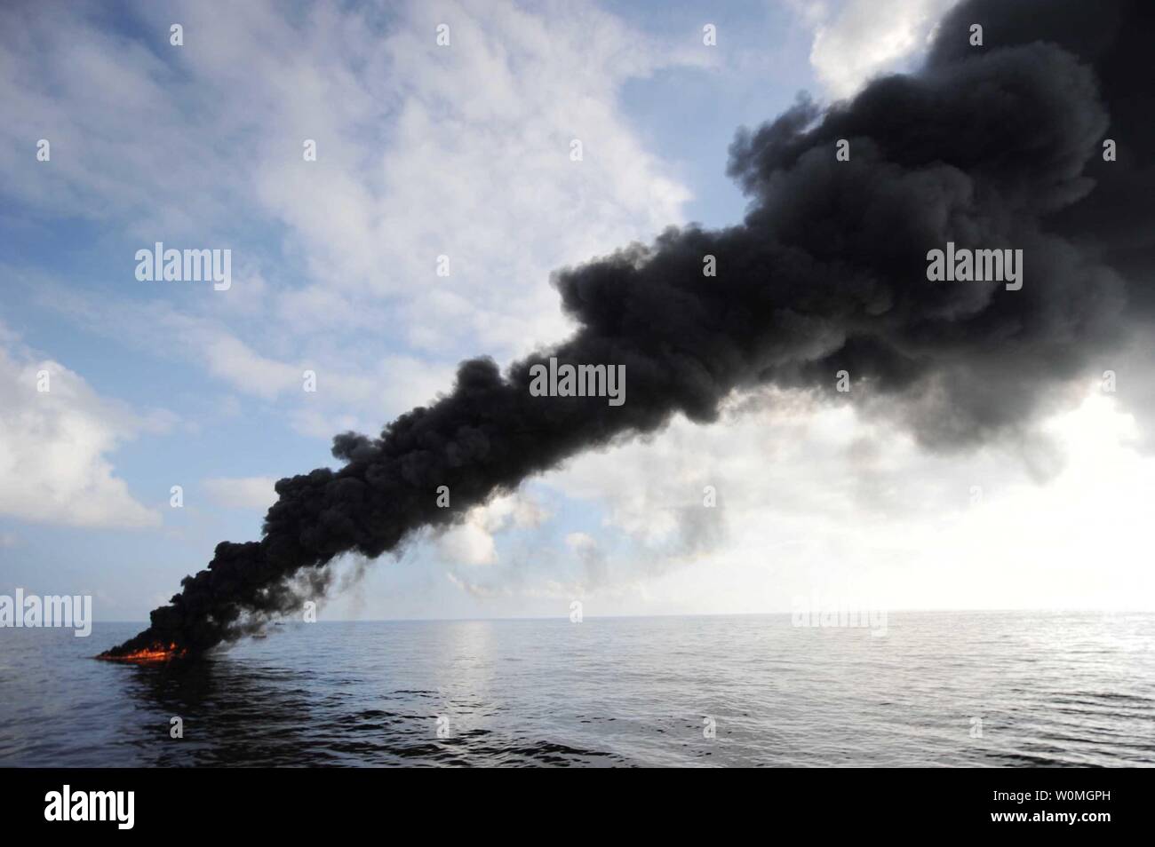 Dark clouds of smoke and fire emerge as oil burns during a controlled fire in the Gulf of Mexico, May 5, 2010.  The 'in situ burn' was conducted by contracted fishing vessels working in partnership with the U.S. Coast Guard, BP PLC, and other federal agencies to aid in preventing the spread of oil following last month's explosion on Mobile Offshore Drilling Unit Deepwater Horizon.  UPI/Justin E. Stumberg/US Navy Stock Photo