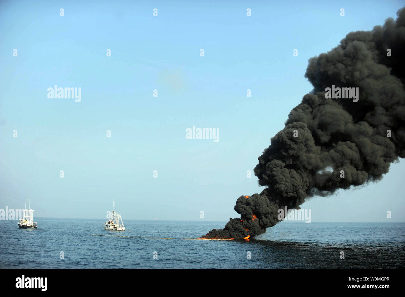 Dark clouds of smoke and fire emerge as oil burns during a controlled fire in the Gulf of Mexico on May 7, 2010. The U.S. Coast Guard working in partnership with BP PLC, local residents, and other federal agencies conducted the 'in situ burn' to aid in preventing the spread of oil following the April 20 explosion on Mobile Offshore Drilling Unit Deepwater Horizon.   UPI/Justin Stumberg/US Navy. Stock Photo