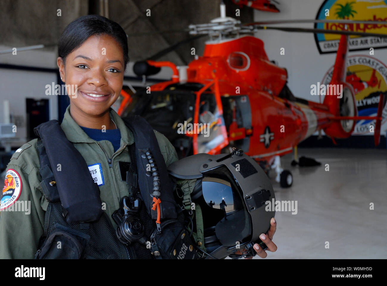 Lt. j.g. Lashanda Holmes stands in front of an MH-65 Dolphin helicopter at Air Station Los Angeles, California on August 17, 2010. Holmes, from Fayetteville, North Carolina, is the first female African-American helicopter pilot in the Coast Guard. UPI/Adam Eggers/U.S. Coast Guard Stock Photo