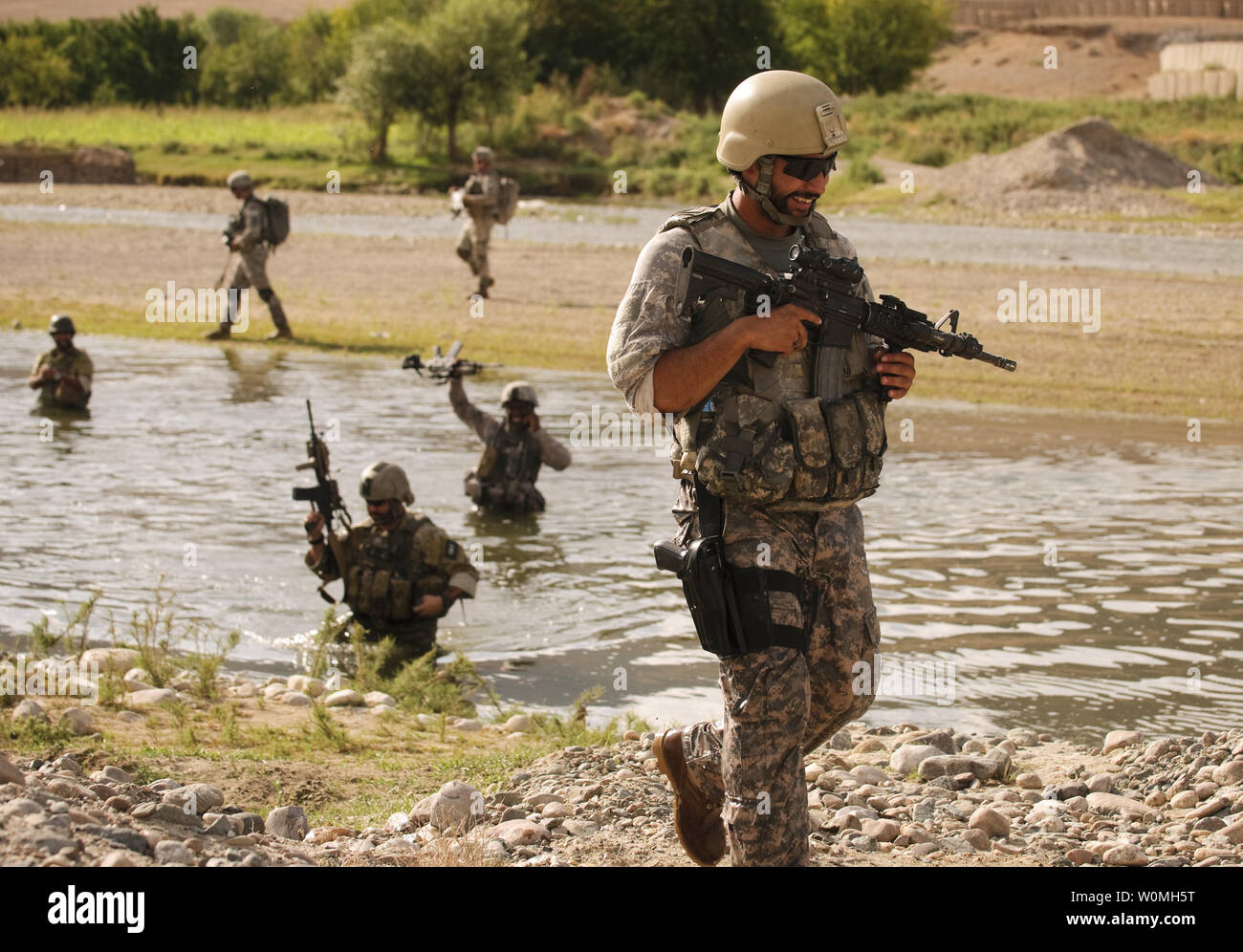 U.S. Army Cpl. Alberto Bhoge, Charlie Company, 478th Civil Affairs Battalion, laughs after crossing a river during a dismounted patrol near Forward Operating Base Lane, Zabul Province, Afghanistan on August 6, 2010. UPI/Nathanael Callon/U.S. Air Force Stock Photo