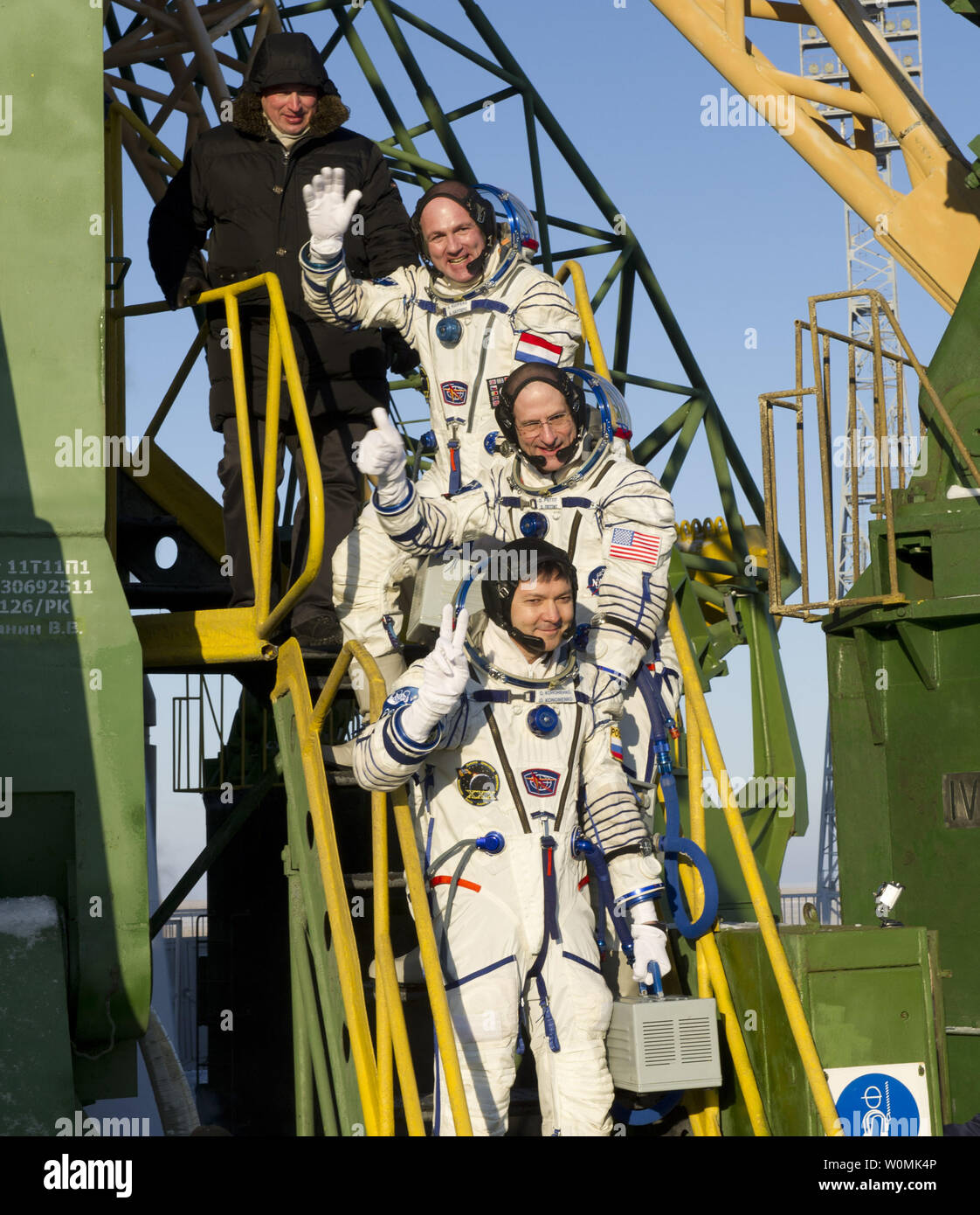 Expedition 30 Soyuz Commander Oleg Kononenko, bottom, NASA Flight Engineer Don Pettit of the U.S., and ESA (European Space Agency) Flight Engineer Andre Kuipers, top, wave farewell from the base of the Soyuz rocket at the Baikonur Cosmodrome in Kazakhstan, Wednesday, Dec. 21, 2011.  Kononenko, Pettit and Kuipers launched in their Soyuz TMA-03M rocket from the Baikonur Cosmodrome at 7:16 p.m. local time.   UPI/NASA/Carla Cioffi Stock Photo