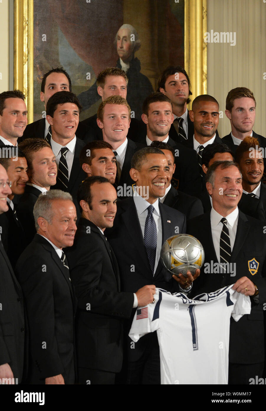U.S. President Barack Obama holds LA Galaxy jersey along with the team under a portrait of President George Washington during during an East Room ceremony honoring players and coaches from the Major League Soccer (MLS) champions LA Galaxy and the Los Angeles National Hockey League (NHL) champions Los Angeles Kings at the White House in Washington, DC on March 26, 2013.  UPI/Pat Benic Stock Photo