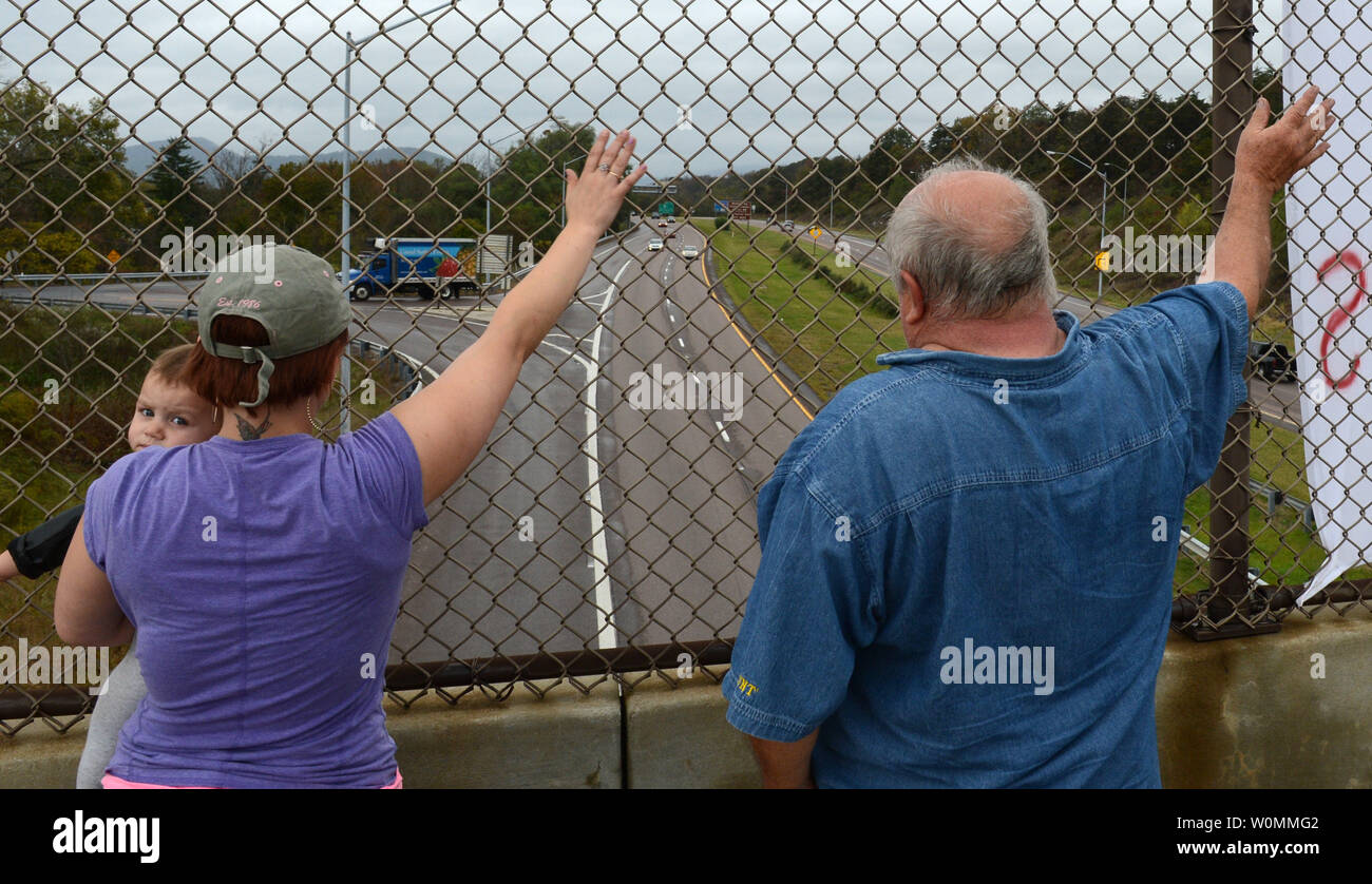 Vietnam Veteran Chip Bosley along with Jessica Hinzman and child Marina wave next to their 'Fire Congress' sign on an overpass along Interstate Highway I-68 in Cumberland, Maryland on October 12, 2013.  On the 12th day of a government shutdown, Bosley said he had to do something to help the common citizen, and said all members of the United States Congress should be fired for shutting down the government and not agreeing to increasing the debt ceiling.  They received plenty of friendly horn honks from drivers.   UPI/Pat Benic Stock Photo