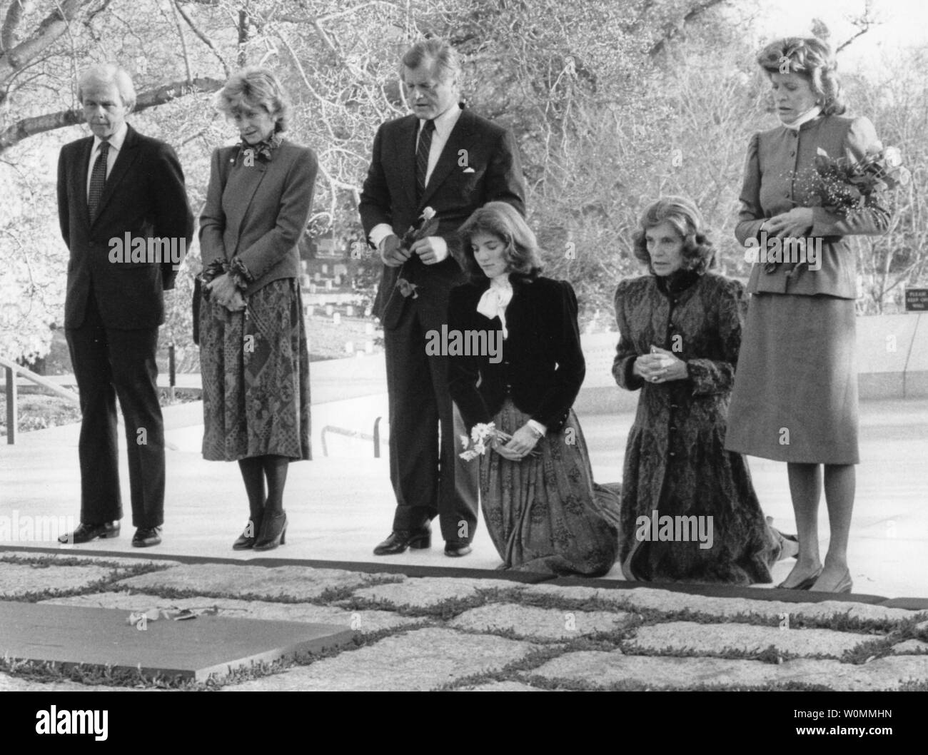 Members of the Kennedy family stand beside the grave of President John ...