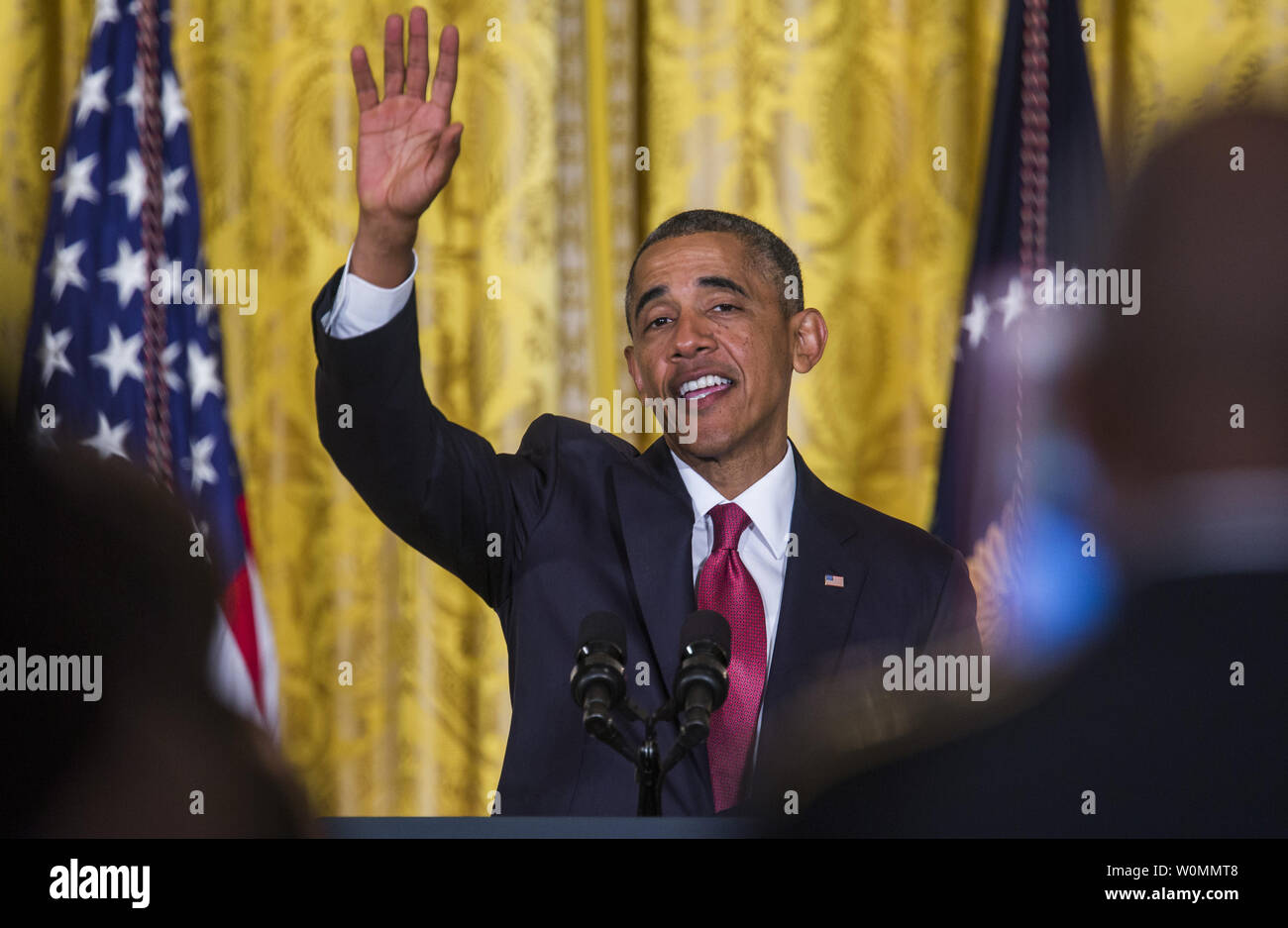 US President Barack Obama waves goodbye after presiding over a naturalization ceremony for active duty service members and civilians in the East Room of the White House in Washington, D.C. on July 4, 2014. The President plans to use executive actions to circumvent congress and move ahead with immigration reform.   UPI/Jim Lo Scalzo Stock Photo