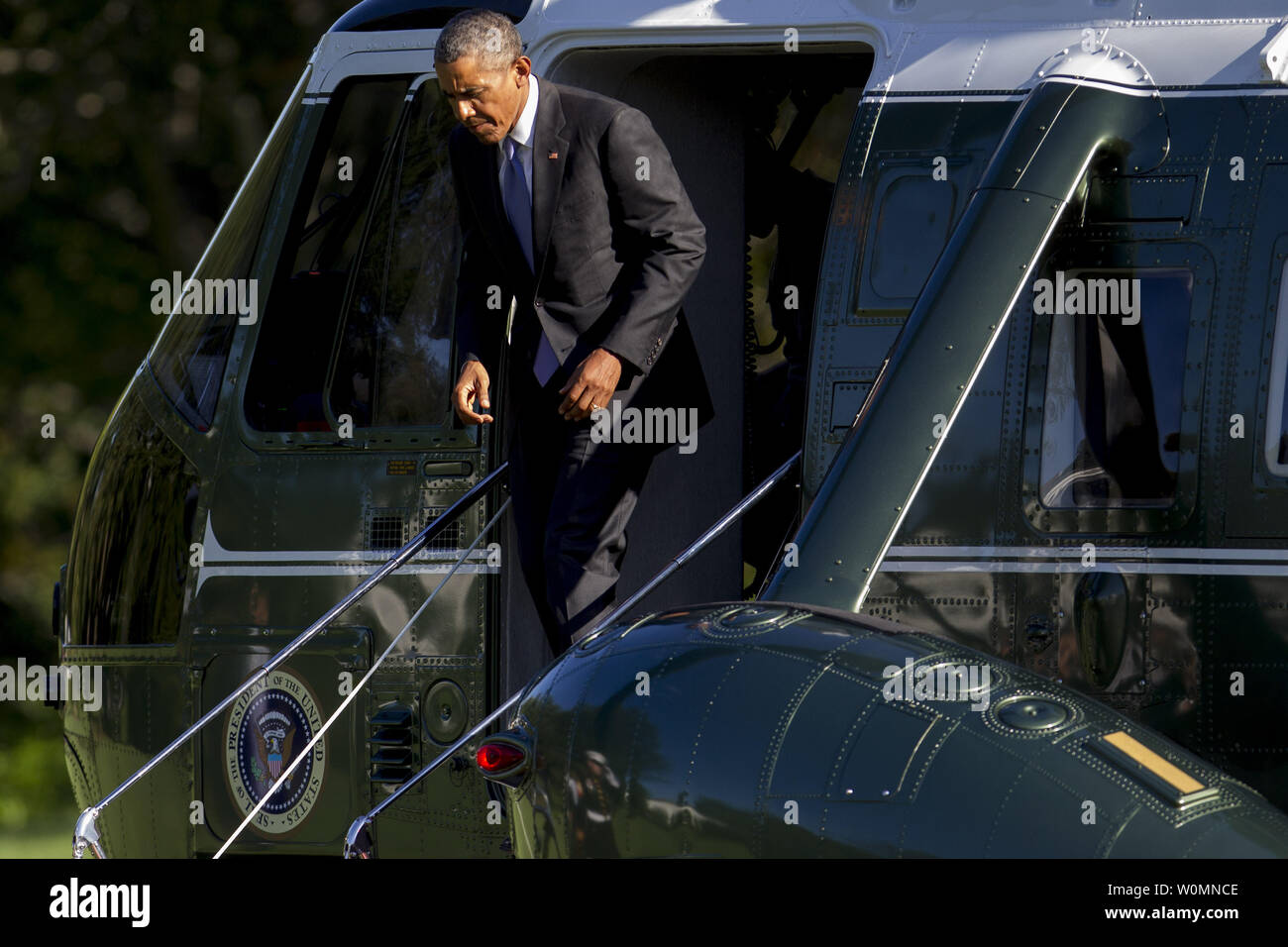 U.S. President Barack Obama walks off of Marine One after landing on the South Lawn of the White House in Washington, D.C., U.S., on Tuesday, Aug. 25. Obama pledged yesterday to provide incentives to support investments in renewable energy, saying the industry will thrive despite opposition by Republicans and fossil-fuel suppliers. Photo by Andrew Harrer/UPI Stock Photo