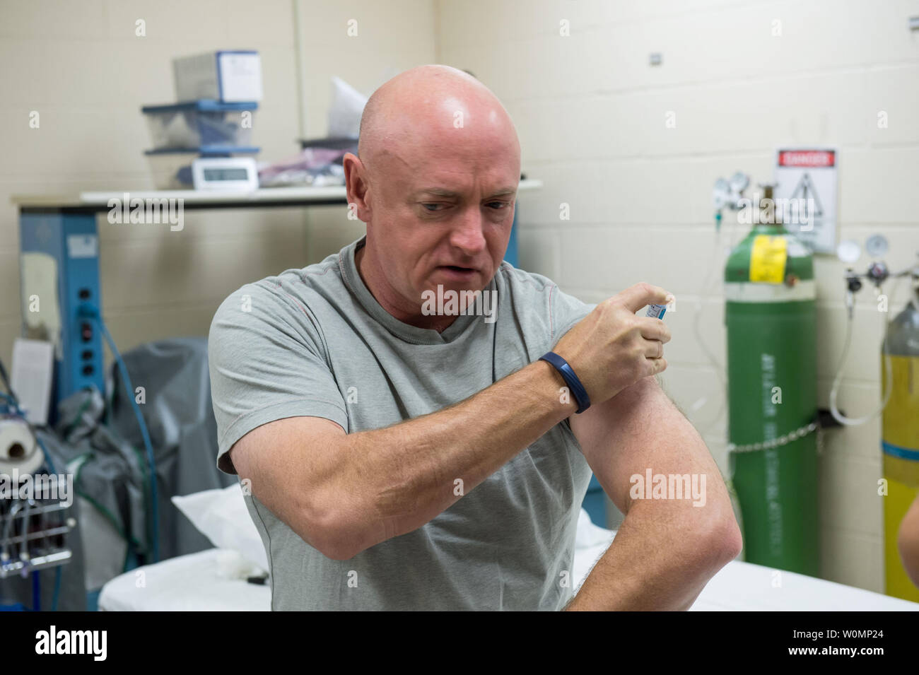Former NASA astronaut Mark Kelly gives himself a flu shot on October 3, 2015 for an ongoing study on the human immune system. The vaccination is part of NASA's Twins Study, a compilation of multiple investigations that take advantage of a unique opportunity to study identical twin astronauts Scott and Mark Kelly, while Scott spends a year aboard the International Space Station and Mark remains on Earth. ..Part of NASA's Human Research Program, the One-Year Mission on the International Space Station is a joint effort between the U.S. space agency, the Russian Federal Space Agency (Roscosmos) an Stock Photo