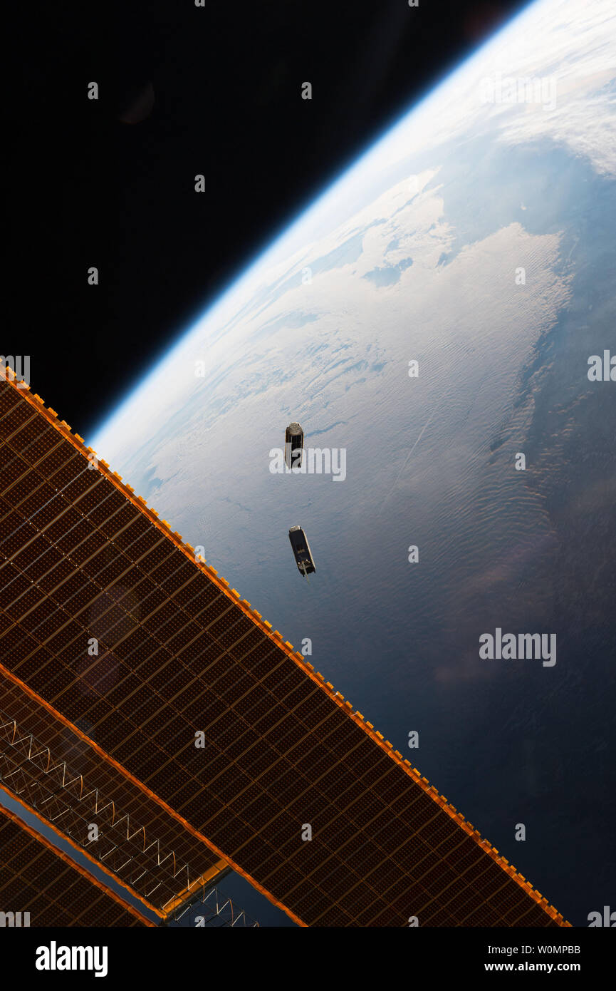 CubeSats fly free after leaving the NanoRacks CubeSat Deployer on the International Space Station on May 17, 2016. Seen here are two Dove satellites, part of a constellation designed, built and operated by Planet Labs Inc. to take images of Earth from space. The images have several humanitarian and environmental applications, from monitoring deforestation and urbanization to improving natural disaster relief and agricultural yields in developing nations. CubeSats are a new, low-cost tool designed to take narrowly targeted scientific observations, with only a few instruments, often built from o Stock Photo