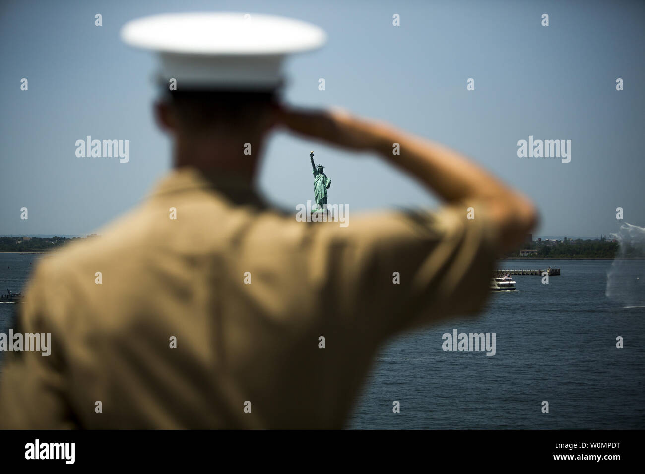 The Statue of Liberty can be seen through the arm of Cpl. Seth Hall, anti-tank missileman, 3rd Battalion, 6th Marine Regiment, as he mans the rails of USS Bataan (LHD-5) in a parade of ships as part of Fleet Week in New York, on May 25, 2016. The Bataan transported more than 500 Marines and sailors with the 24th Marine Expeditionary Unit who will participate in this yearÕs Fleet Week. Photo by Sgt. Rebecca L. Floto/U.S. Marine Corps/UPI Stock Photo