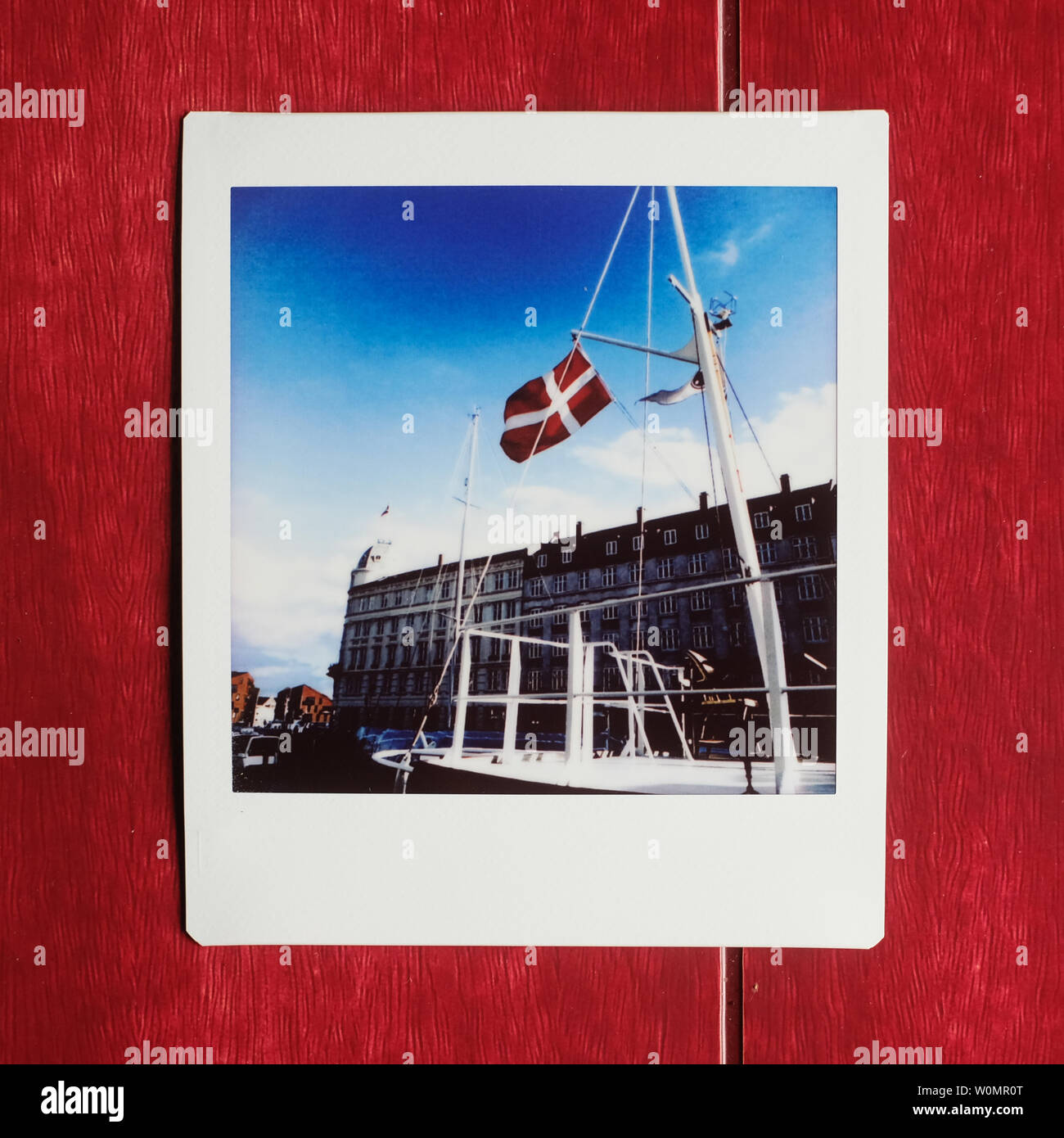 Polaroid of a boat/ship with the flag of denmark in the nyhavn harbour in copenhagen Stock Photo