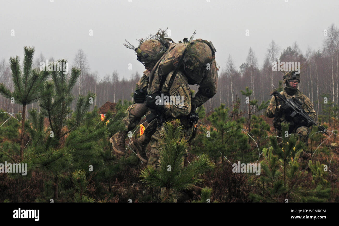 A Paratrooper from Able Company, 2nd Battalion, 503rd Infantry Regiment, 173rd Infantry Brigade Combat (Airborne), carries a ÒwoundedÓ comrade off the battlefield November 24 during Exercise Iron Sword 2016. Iron Sword is an international training exercise featuring 11 NATO countries and about 4,000 troops. The exercise is designed to test promote regional stability and security, while strengthening partnership capacity, and fostering trust while improving the ability to conduct joint training between Lithuania, the U.S., and NATO member nations. Photo by Staff Sgt. Corinna Baltos/U.S. Army/UP Stock Photo