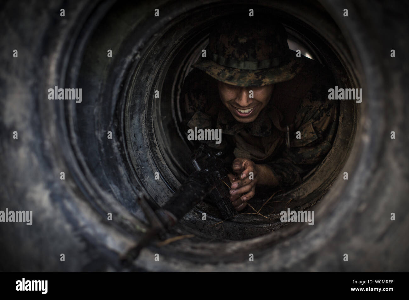 U.S. Marine Corps Cpl. Manuel Serrano, a combat videographer with the Combat Camera section, Marine Corps Combat Service Support Schools, moves through a tire obstacle while navigating an obstacle course on Camp Johnson, N.C., December 12, 2016. The Combat Camera Marines ran through multiple obstacle courses as part of section physical training in order to maintain a state of constant readiness and strengthen unit cohesion. Photo by Andrew Kuppers/U.S. Marine Corps/UPI Stock Photo
