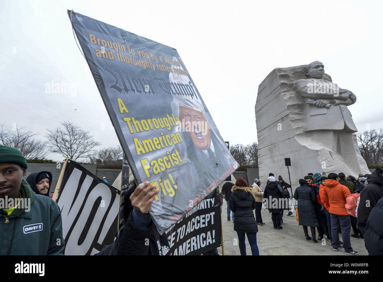 Demonstrators hold signs during an annual wreath laying ceremony hosted by The Memorial Foundation in partnership with the Faith and Politics Institute, IMPACT, and The Asian American Lead School at the Martin Luther King, Jr. Memorial in Washington, DC on January 16, 2017. Photo by Leigh Vogel/UPI Stock Photo