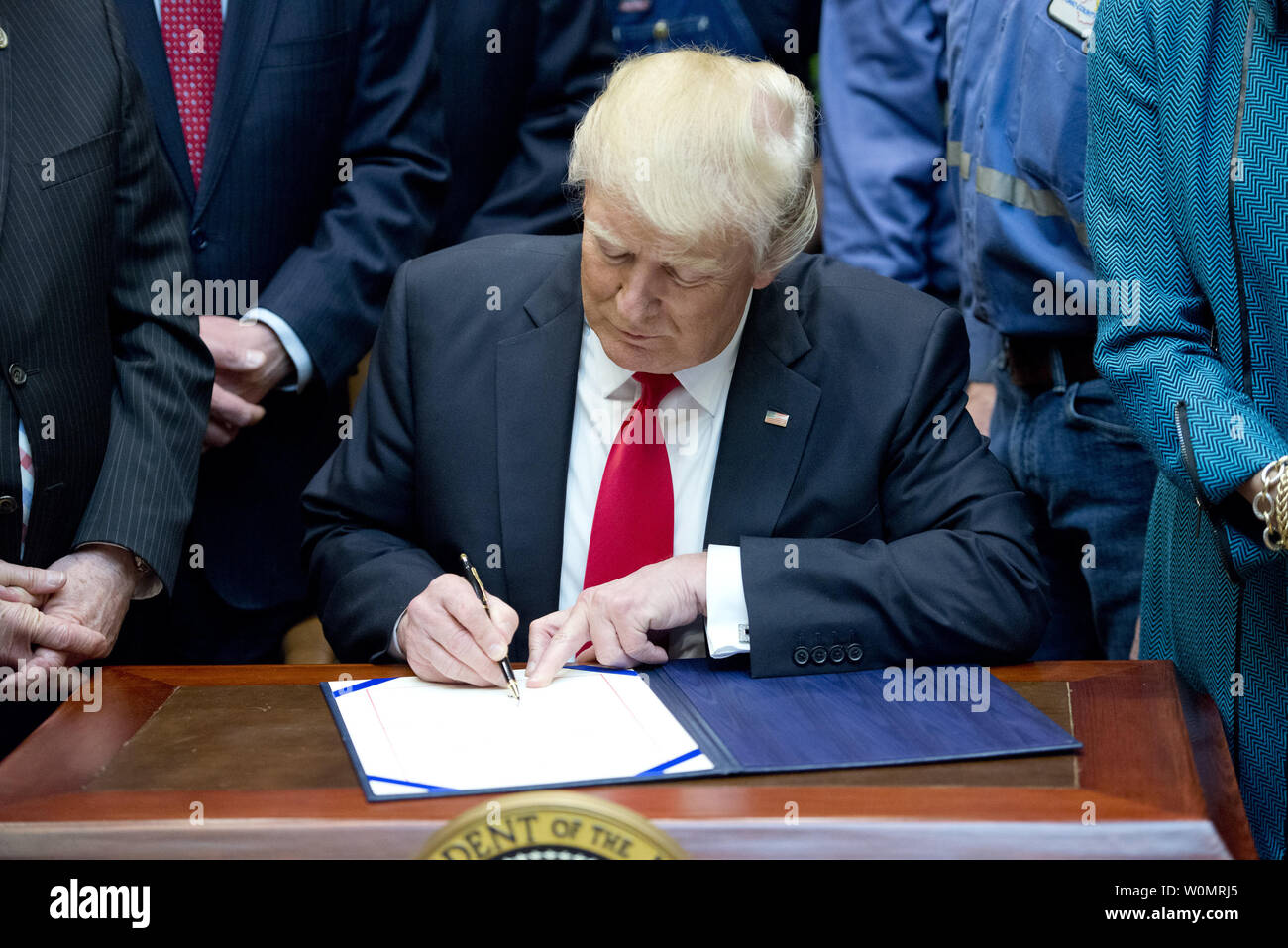 United States President Donald J. Trump signs H.J. Res. 38, disapproving the rule submitted by the US Department of the Interior known as the Stream Protection Rule in the Roosevelt Room of the White House in Washington, DC on February 16, 2017.  The Department of Interior's Stream Protection Rule, which was signed during the final month of the Obama administration, 'addresses the impacts of surface coal mining operations on surface water, groundwater, and the productivity of mining operation sites,' according to the Congress.gov summary of the resolution..Credit: Ron Sachs / Pool via CNP Stock Photo