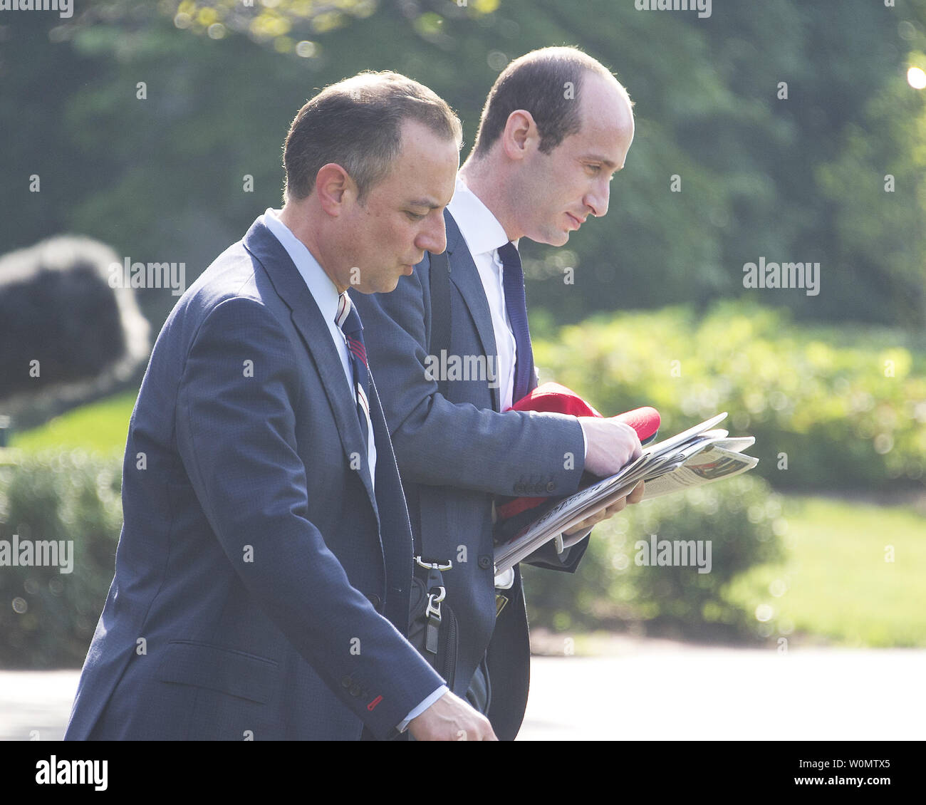 White House Chief of Staff Reince Priebus, left, and Senior Advisor for Policy Stephen Miller, right, walk to Marine One to accompany United States President Donald J. Trump as he departs the White House in Washington, DC to participate in the commissioning ceremony for the USS Gerald R. Ford (CVN-78), the latest US Navy supercarrier, on July 22, 2017.         Photo by Ron Sachs/UPI Stock Photo