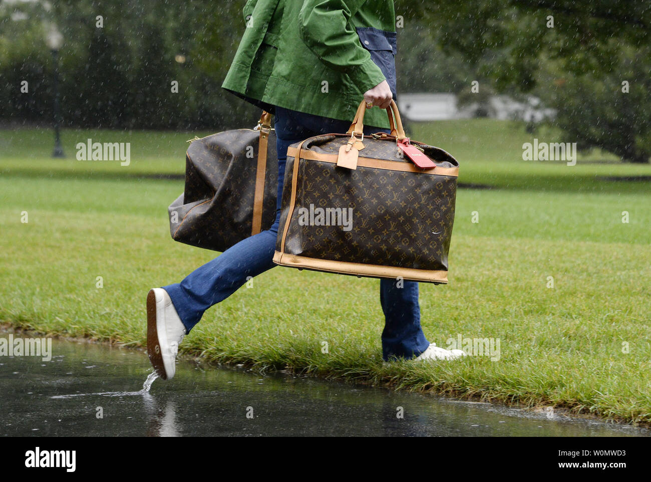 A White House aide carries Louis Vuitton 's bags prior to