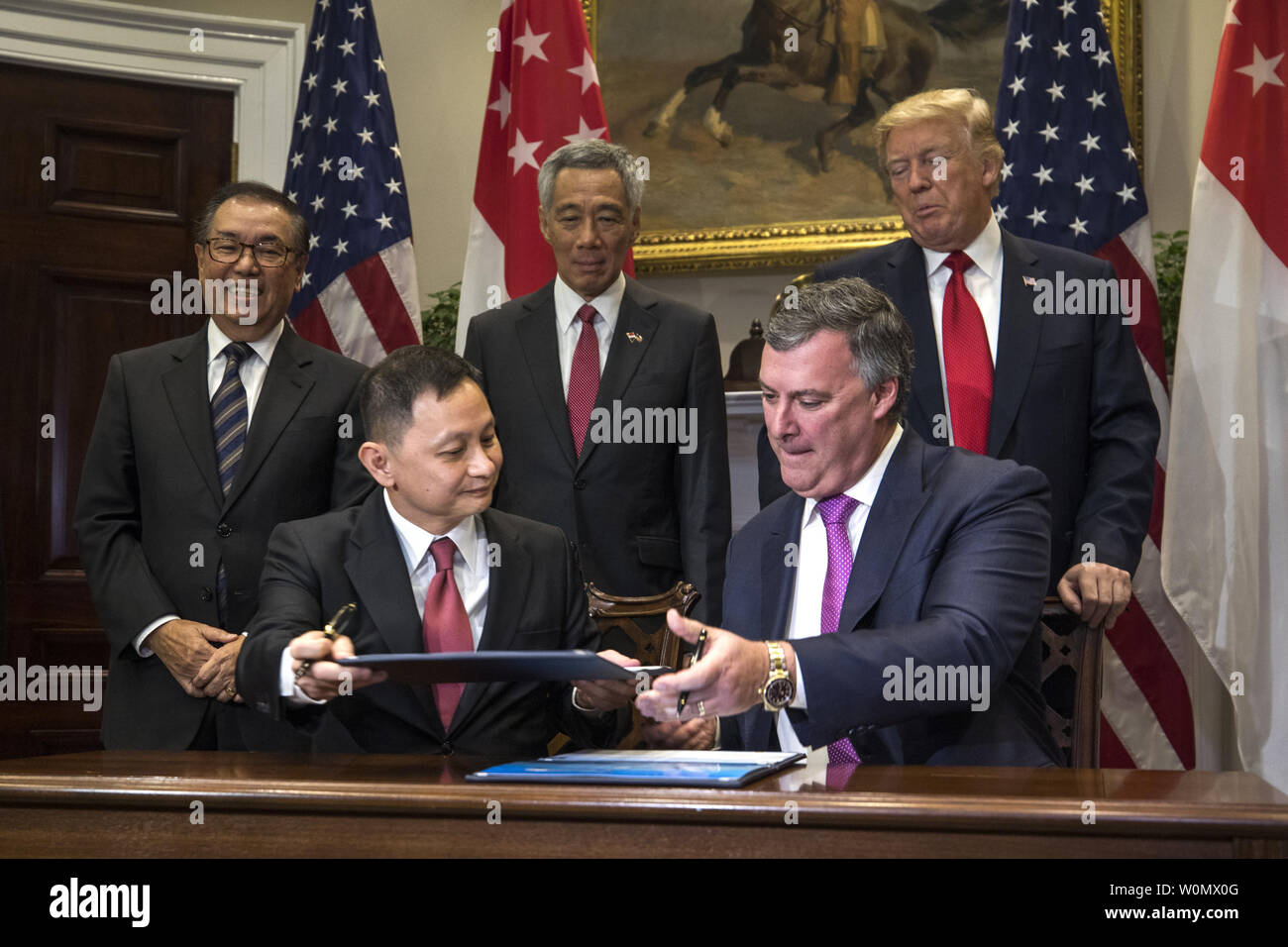 Boeing Executive Vice President Kevin McAllister (R) and CEO of Singapore Airlines Goh Choon Phong (C-L) along US President Donald Trump (C-R) and Lee Hsien Loong (C) of Singapore attend a signing ceremony for airplane sales in the Roosevelt Room at the White House in Washington, DC, on October 23, 2017. The meeting comes less than two weeks before President Trump makes an extended trip to the Asia-Pacific region. . Photo by Jim Louis Scalzo/UPI Stock Photo