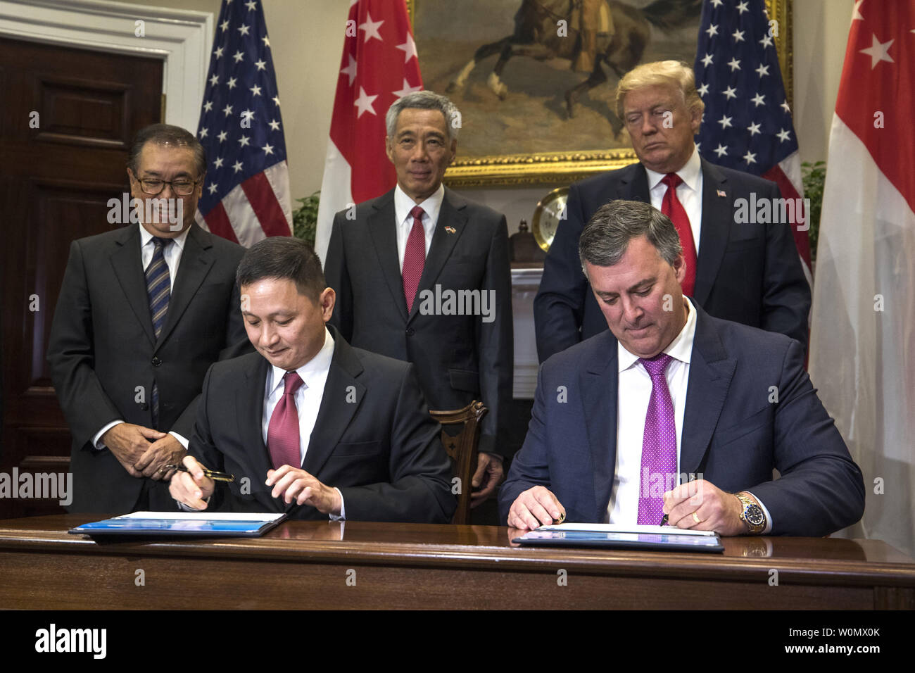 Boeing Executive Vice President Kevin McAllister (R) and CEO of Singapore Airlines Goh Choon Phong (C-L) along US President Donald Trump (C-R) and Lee Hsien Loong (C) of Singapore attend a signing ceremony for airplane sales in the Roosevelt Room at the White House in Washington, DC, on October 23, 2017. The meeting comes less than two weeks before President Trump makes an extended trip to the Asia-Pacific region. . Photo by Jim Louis Scalzo/UPI Stock Photo