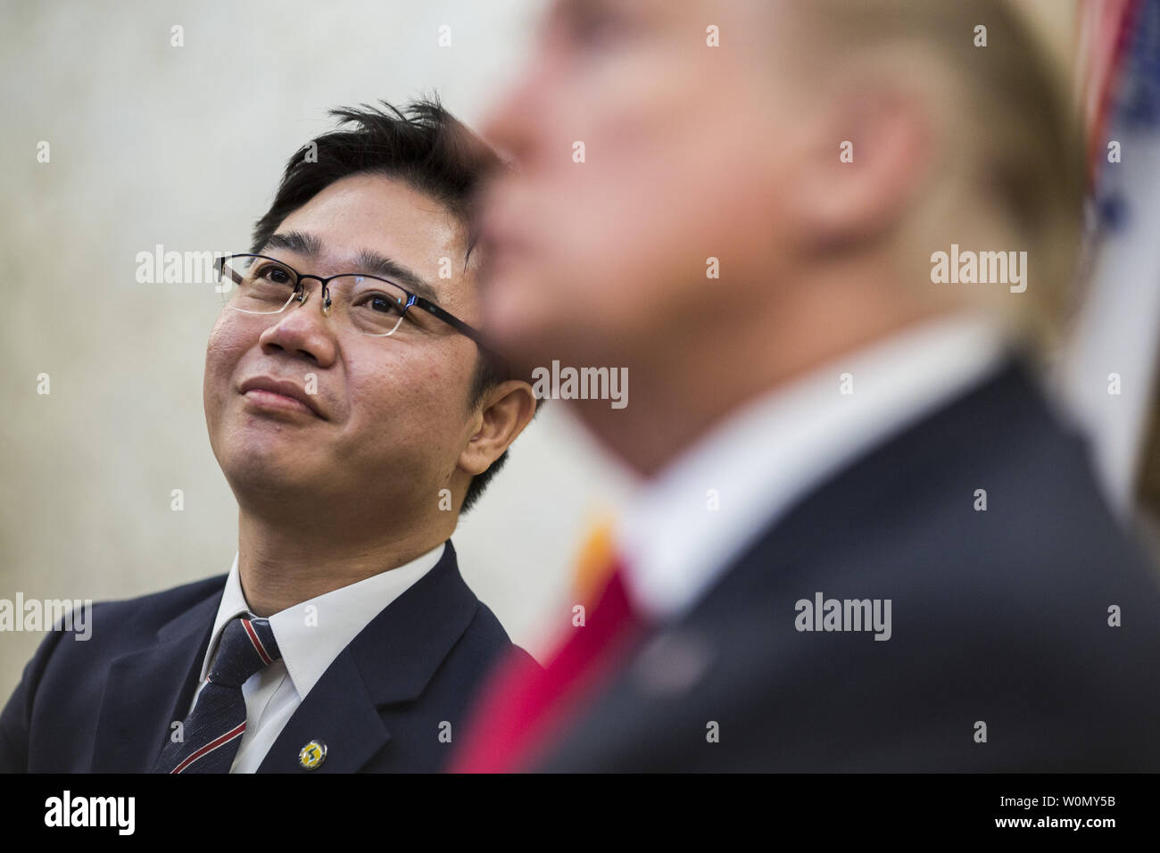 North Korean defector Ji Seong-ho (L) listens as U.S. President Donald Trump meets with North Korean defectors in the Oval Office of the White House in Washington, D.C. on February  2, 2018. Trump's meeting is one week before the Winter Olympics in Pyeongchang, South Korea, in which North Korea will be participating.    Photo by Zach Gibson/UPI Stock Photo