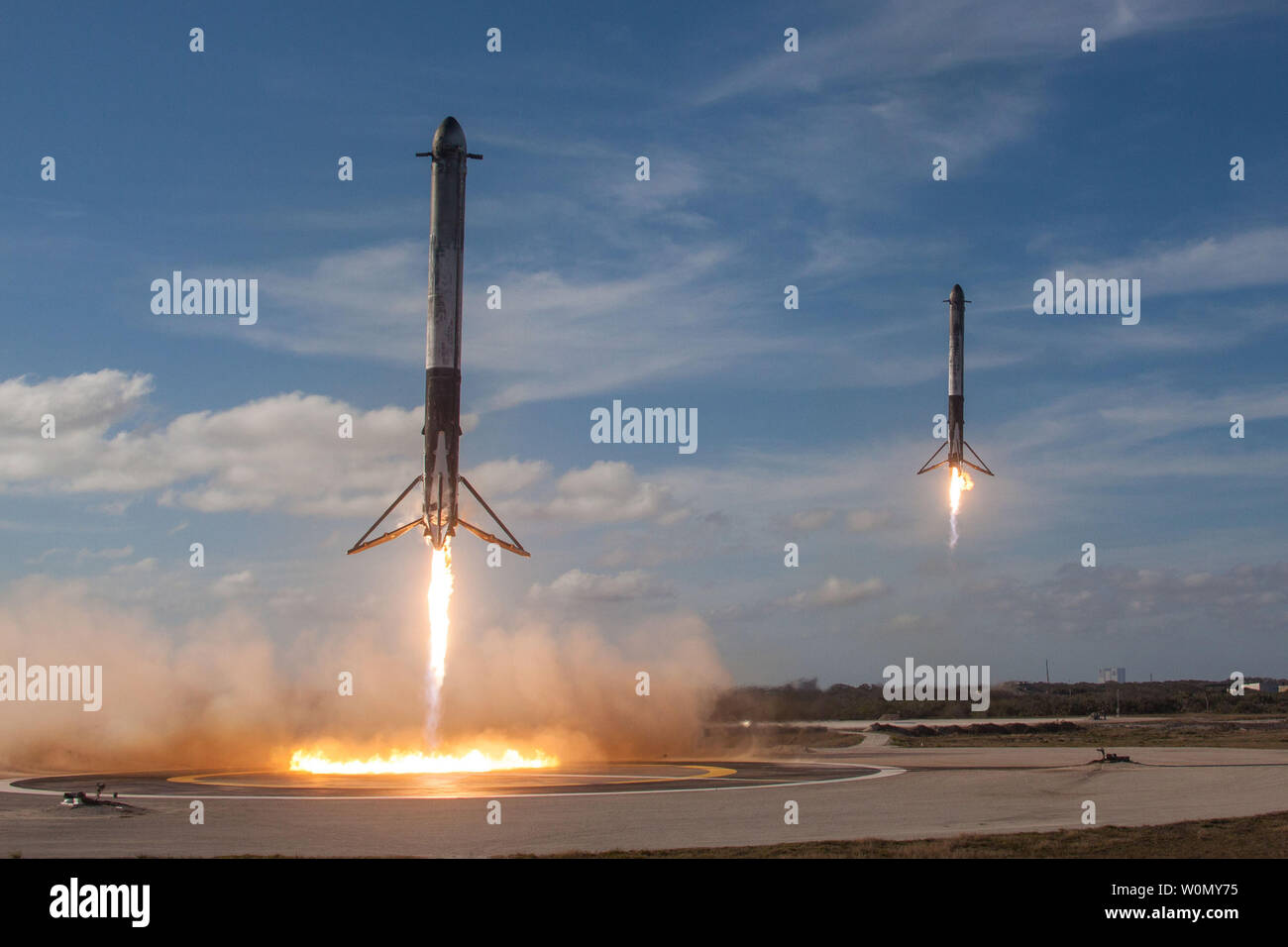 Two of the booster rockets return to to be reused after SpaceX launched ...