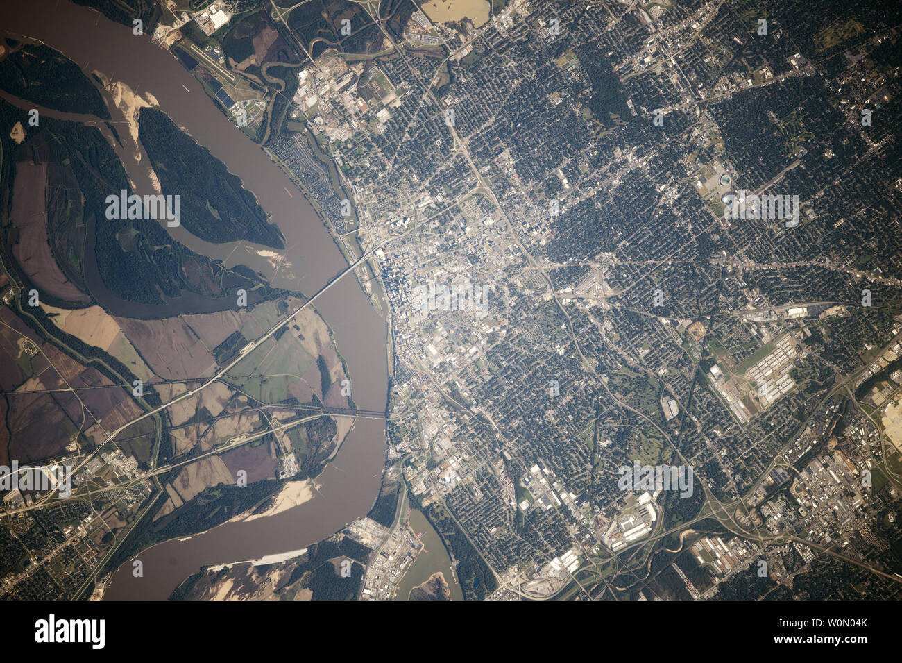Astronauts aboard the International Space Station took this photograph of Memphis, Tennessee, also known as 'Bluff City' because of its location on high bluffs above the flood levels of the Mississippi River, on October 30, 2014. The city center sits next to the mud-brown Mississippi. Surrounding suburbs are green and have a distinctly darker tone. Major roads radiate from the city center, cutting the cityÕs street grid pattern. The runway of a local airport appears next to the river (top left). The low country opposite the city center is dominated by farms and the broad sweep of ancient meand Stock Photo