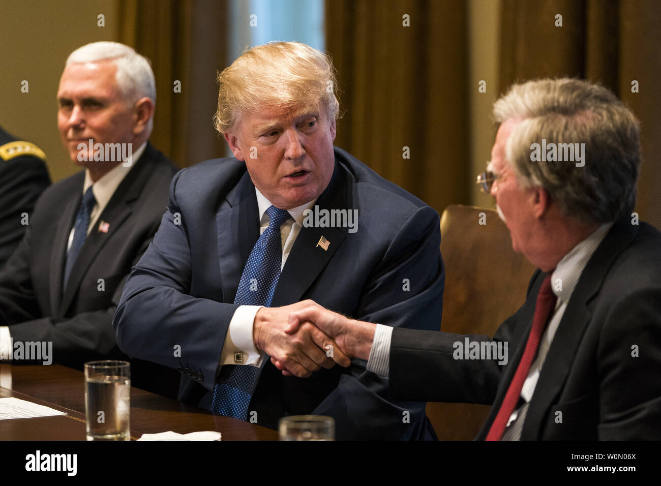 US President Donald J. Trump (L) shakes hands with his new National Security Advisor John Bolton (R) as he speaks with the media before a meeting with his military leadership in the Cabinet Room of the White House in Washington DC, on April 9, 2018. Trump said he will decide in the next few days whether the US will respond militarily for the reported chemical weapons attack in Syria. Trump also spoke about the FBI raid of his personal attorney Michael Cohen's office.      Photo by Jim Lo Scalzo/UPI Stock Photo
