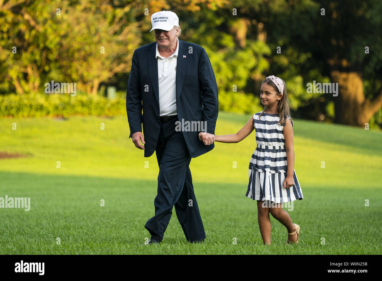 U.S. President Donald J. Trump (L) and his granddaughter Arabella Rose Kushner (R) walk across the South Lawn as they return from a weekend stay in Bedminster, New Jersey at the White House in Washington, DC, on July 29, 2018. Earlier in the day, the President once again went after the media on Twitter, calling them the 'enemy of the people.'     Photo by Jim Lo Scalzo/UPI Stock Photo
