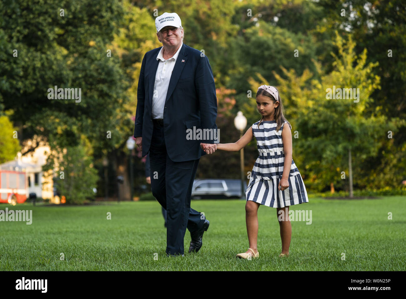 U.S. President Donald J. Trump (L) and his granddaughter Arabella Rose Kushner (R) walk across the South Lawn as they return from a weekend stay in Bedminster, New Jersey at the White House in Washington, DC, on July 29, 2018. Earlier in the day, the President once again went after the media on Twitter, calling them the 'enemy of the people.'     Photo by Jim Lo Scalzo/UPI Stock Photo