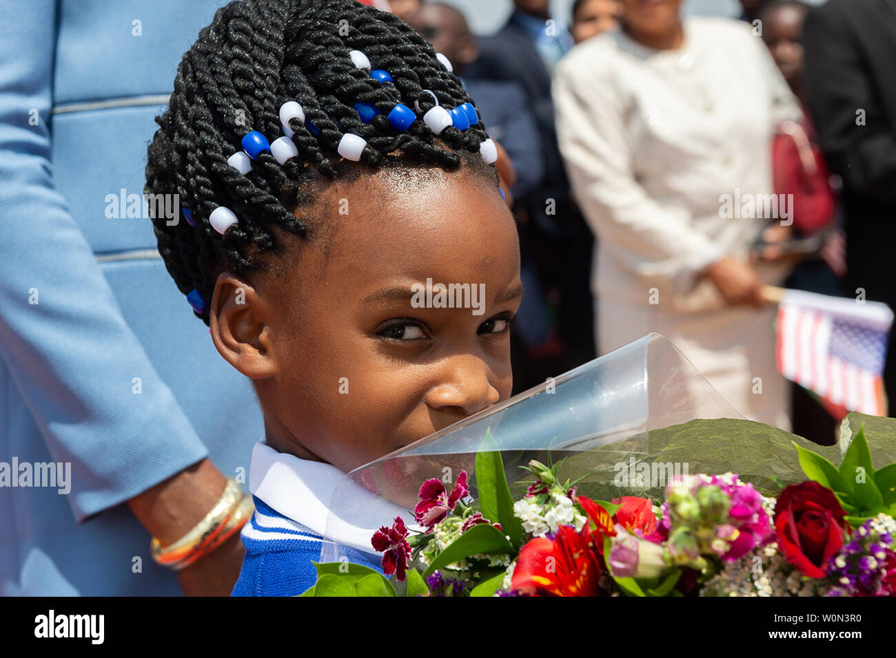 A Flower Girl Holds A Bouquet Of Flowers That Will Be Given To