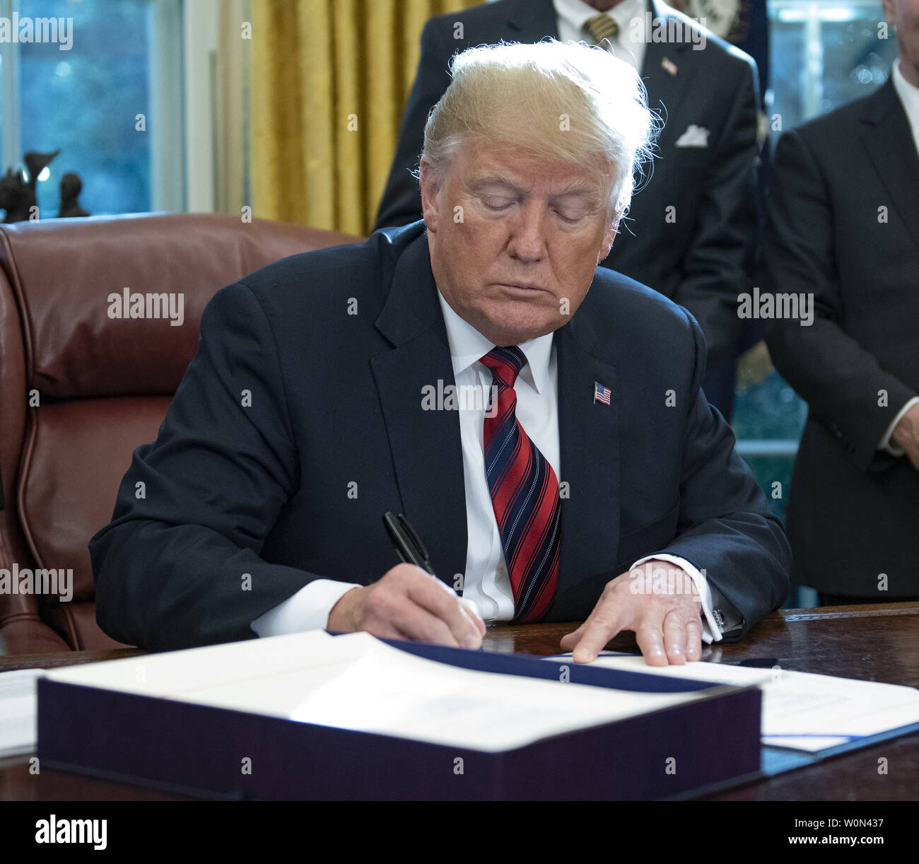 United States President Donald J. Trump signs S.3021, America’s Water Infrastructure Act of 2018 in the Oval Office of the White House in Washington, DC on Tuesday, October 23, 2018.  After signing the bill, the President took questions from the pool on the caravan and Saudi Arabia.       Photo by Ron Sachs/UPI Stock Photo