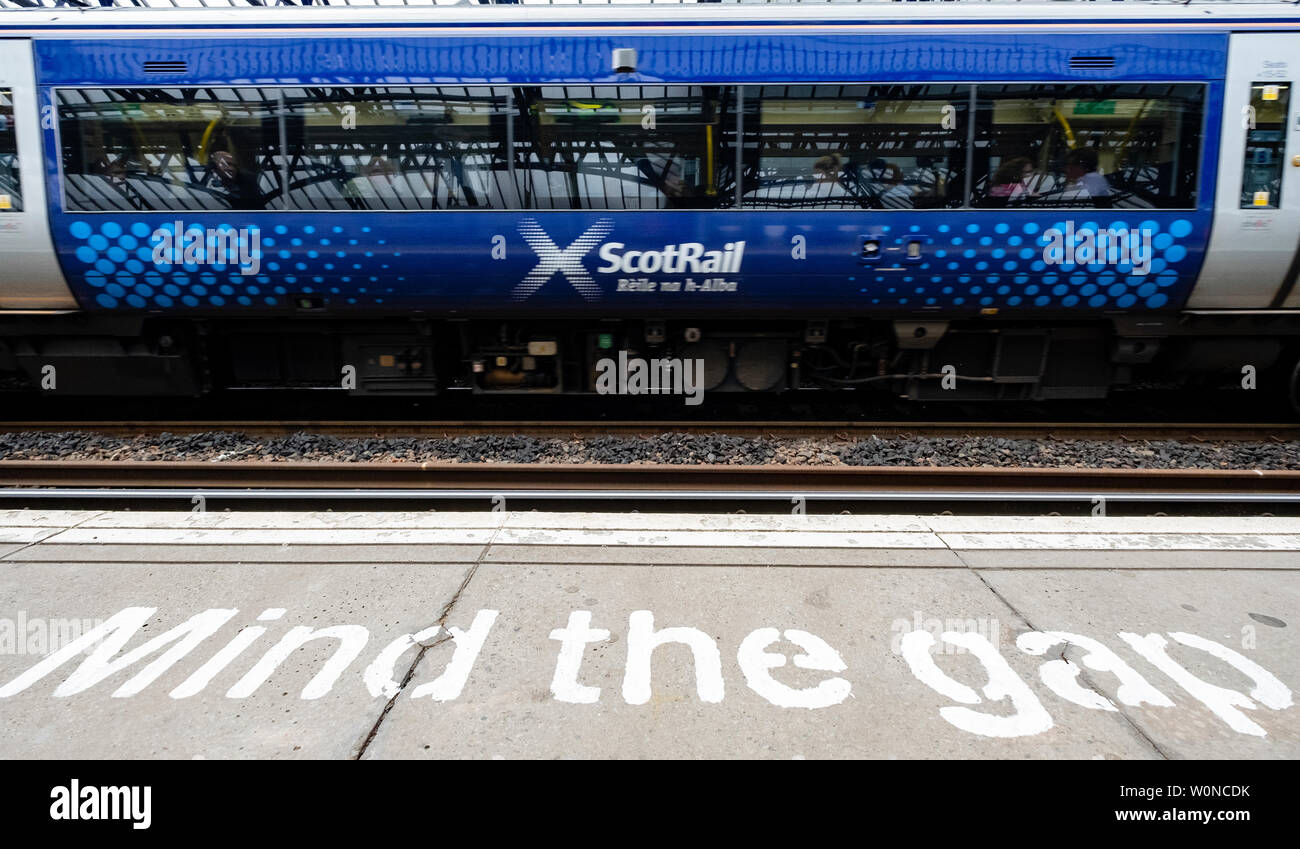 View of Scotrail passenger train at station platform with Mind the Gap warning painted on edge, Stirling, Scotland, UK Stock Photo